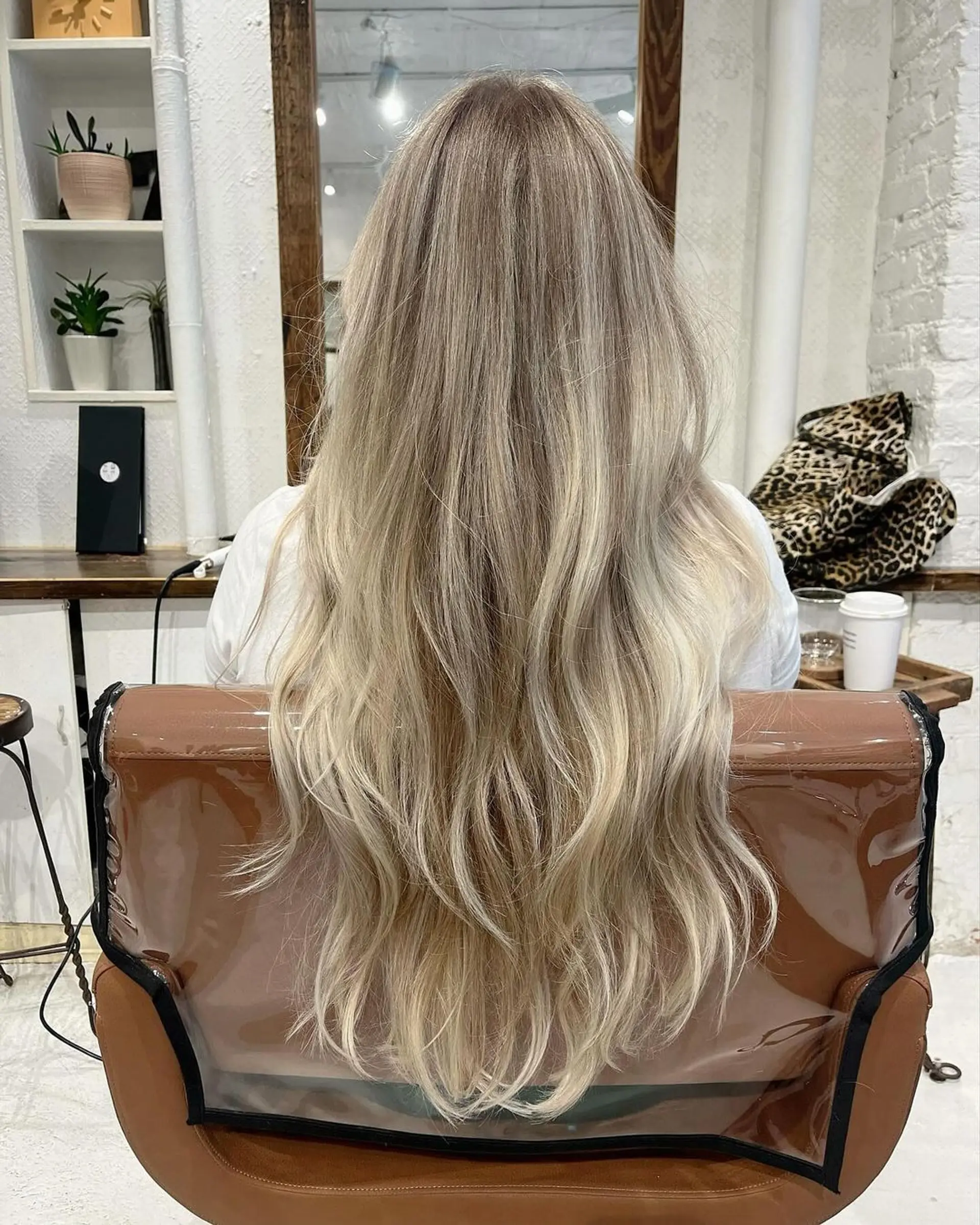 Very long, wavy hair with blonde, golden, and honey tones and softly layered waves, enhanced with blended highlights. 2