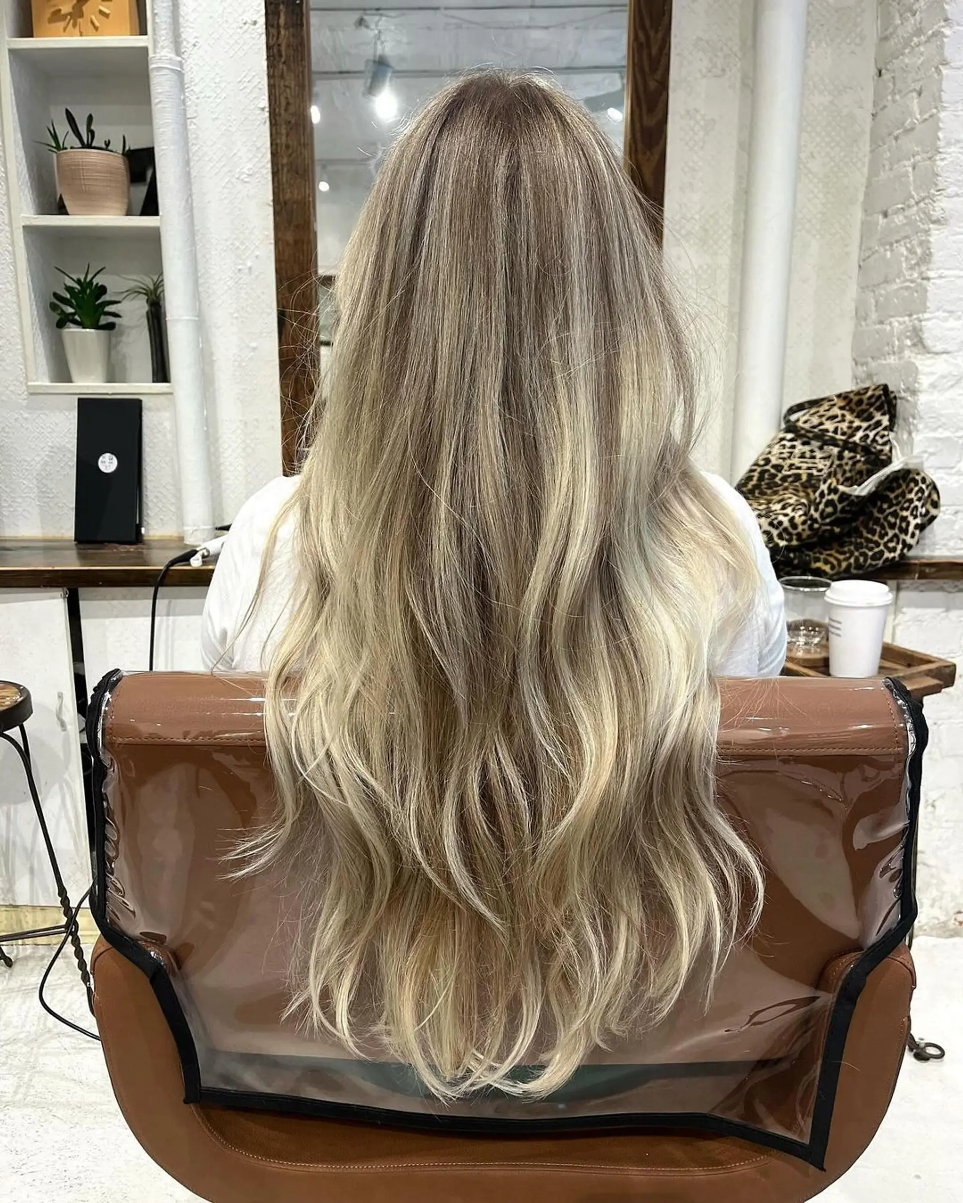 Very long, wavy hair with blonde, golden, and honey tones and softly layered waves, enhanced with blended highlights. 1