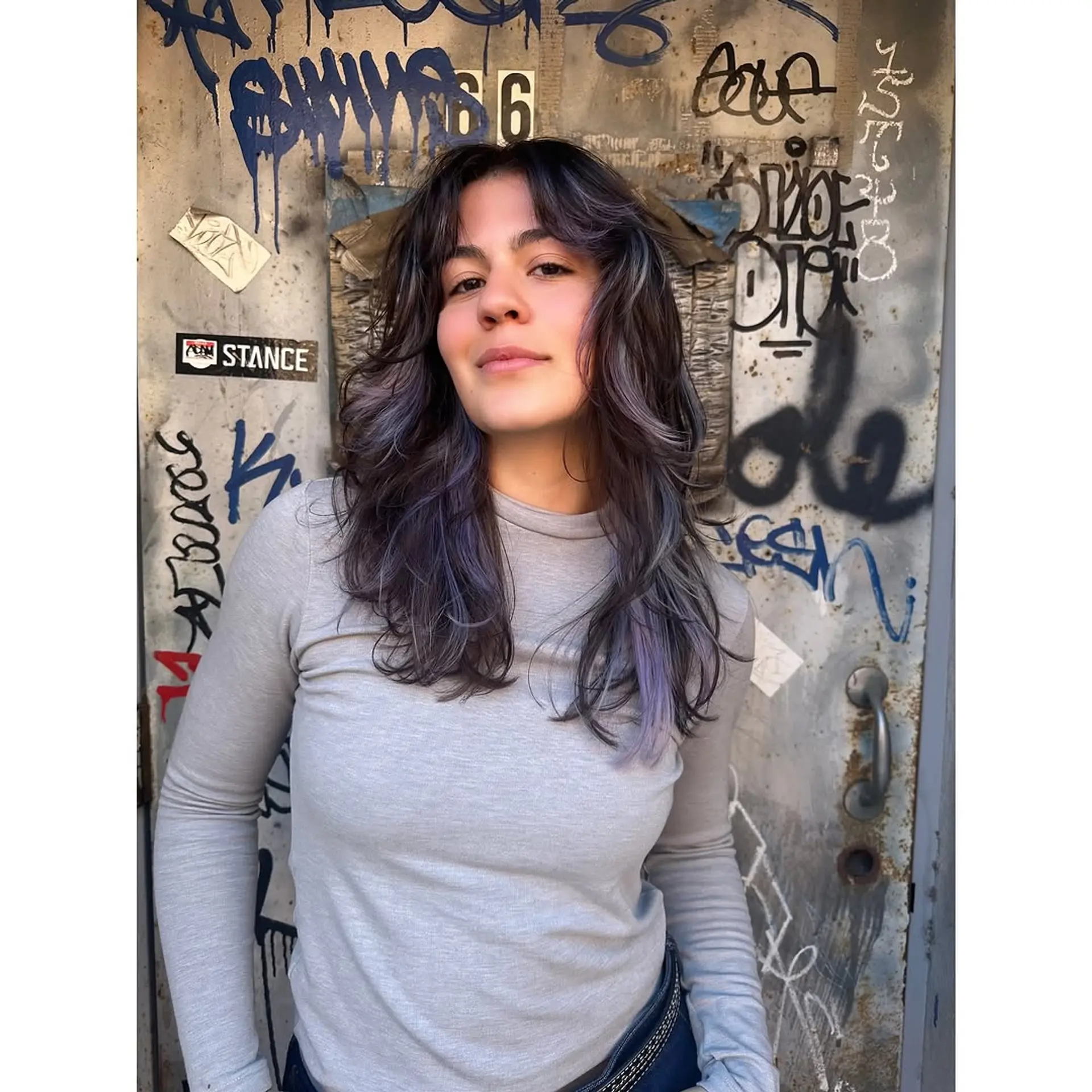 A wavy, medium-length shag with face-framing layers and subtle lavender highlights. 1