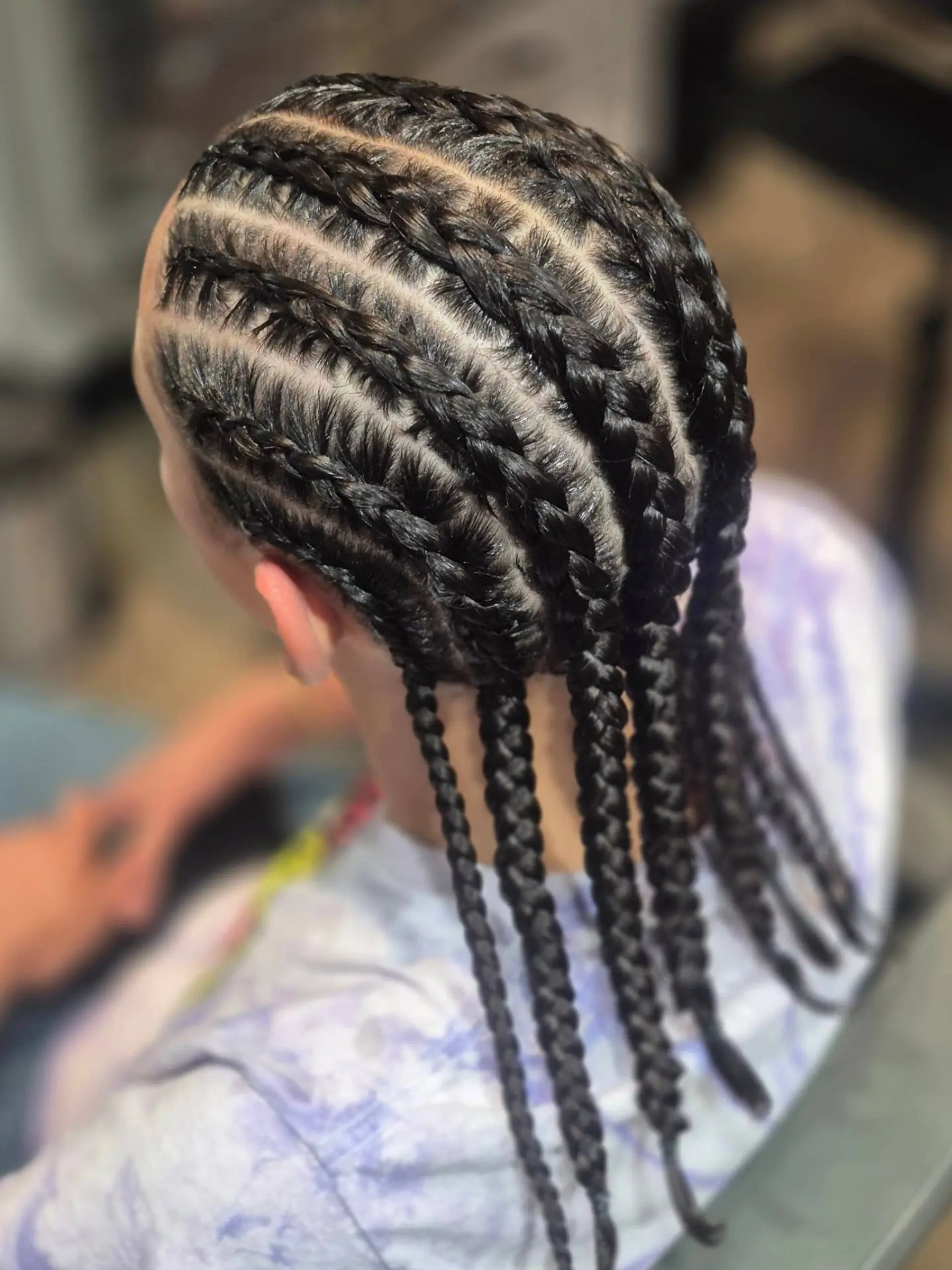 Neat, symmetrical straight-back cornrows braided along the scalp into hanging individual plaits. 1