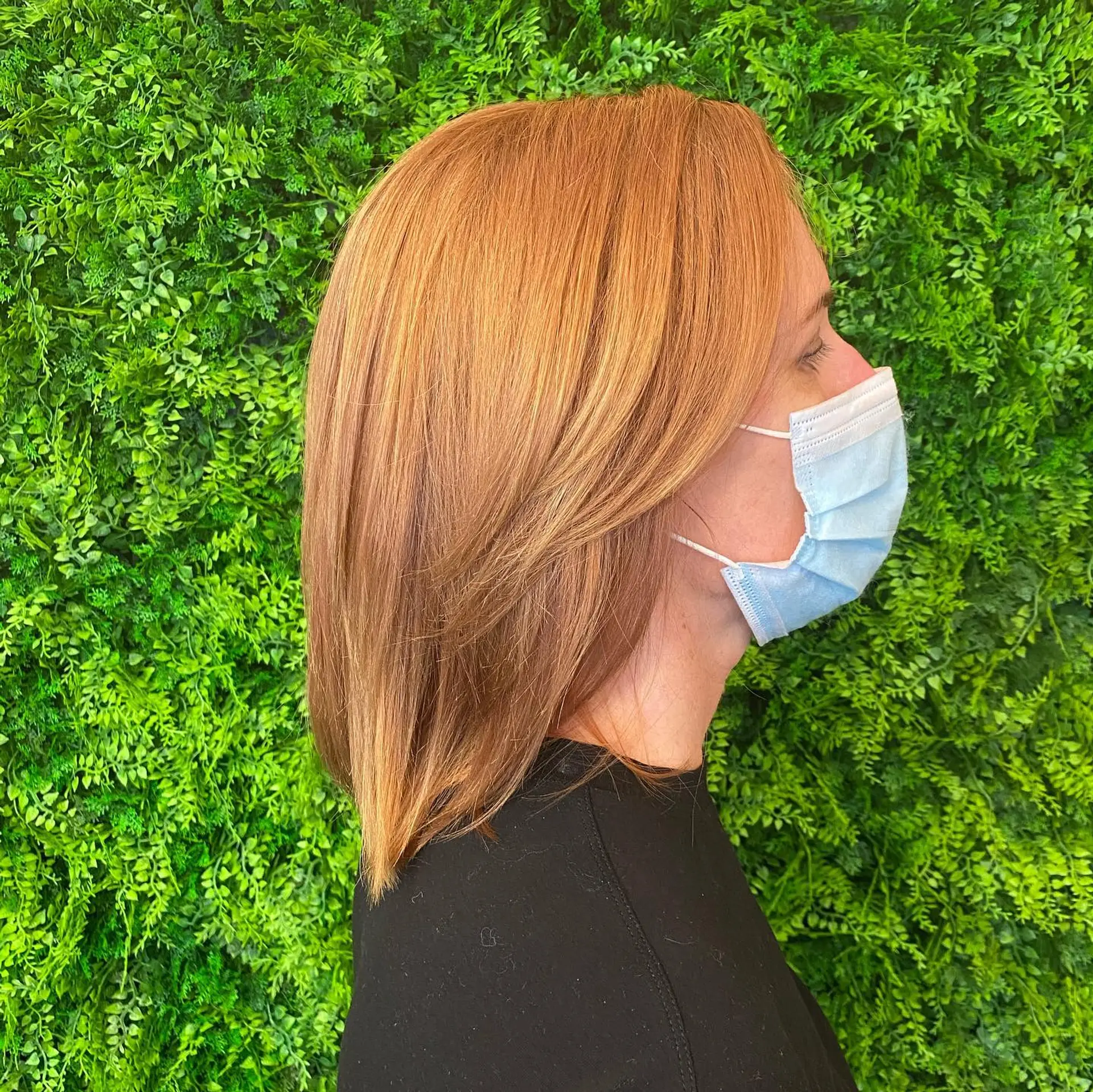 A vibrant ginger copper medium-length lob styled straight with subtle face-framing layers. 1