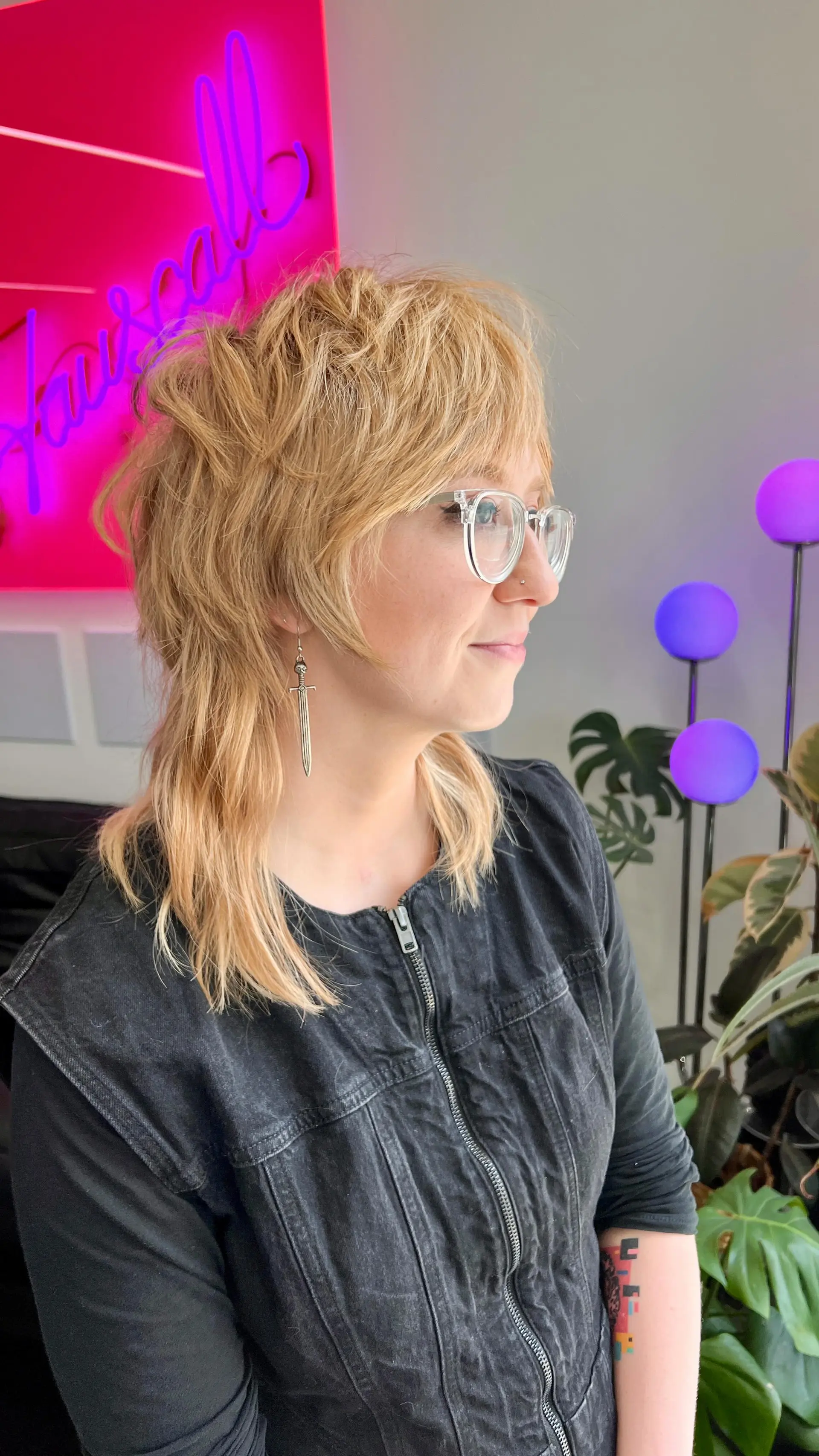 A textured warm blonde shag mullet with choppy feathered layers, full bangs, and shoulder-skimming length. 1