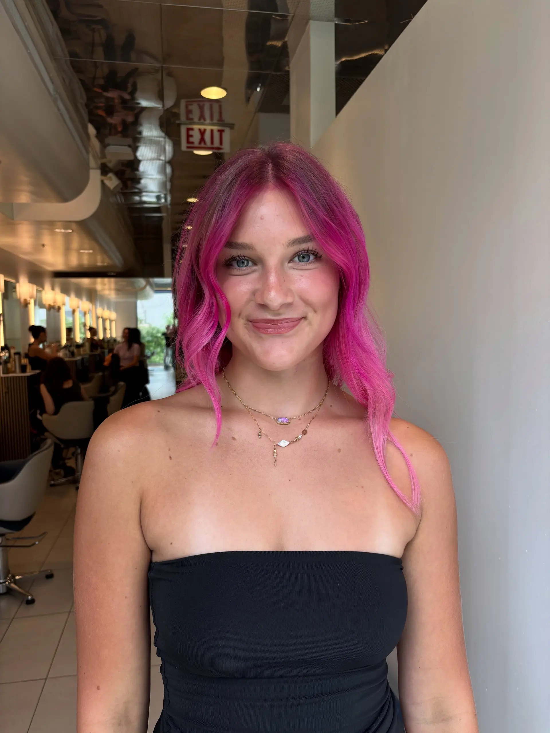Vibrant hot pink hair cut into a textured collarbone-length lob with soft face-framing waves and a middle part. 1