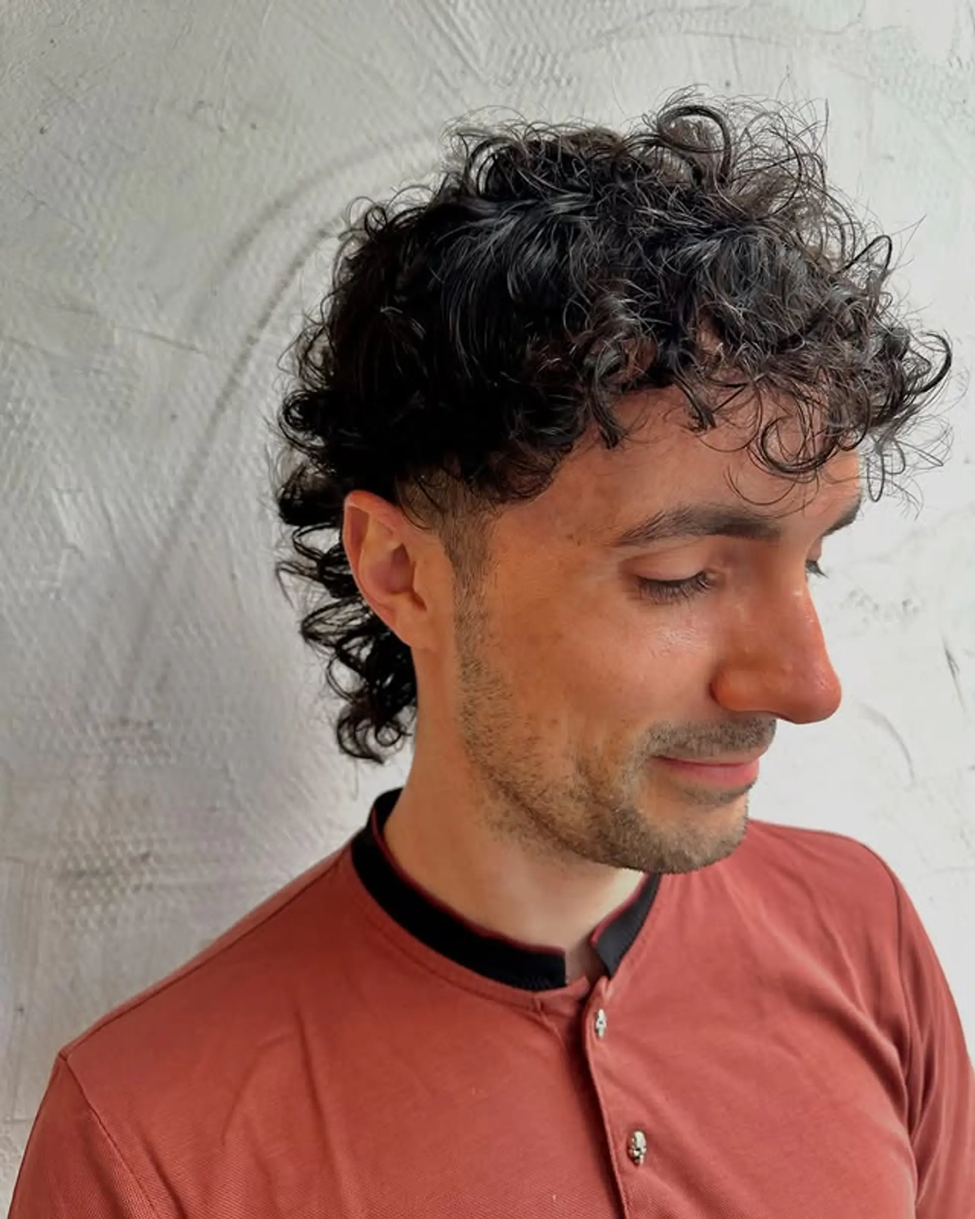A modern take on the classic mullet featuring defined curls on top and a distinctive longer length at the back. 1