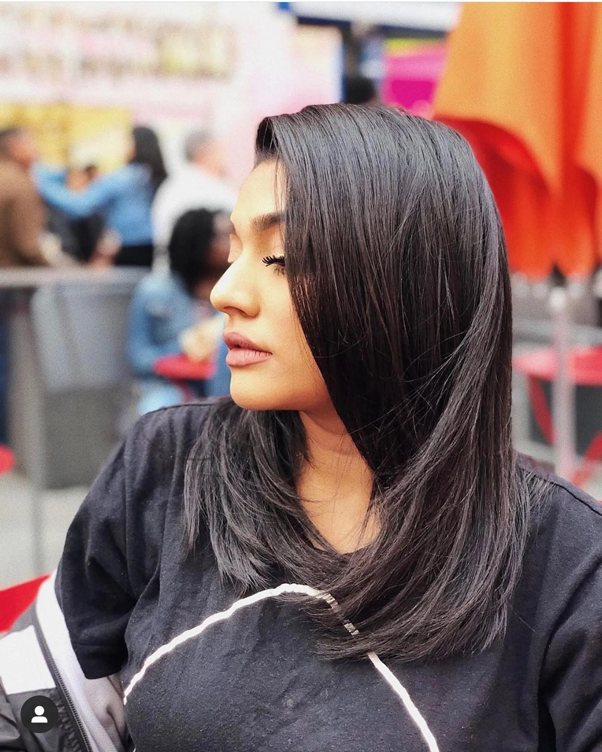 A sleek, high-shine black silk press styled with smooth side-swept layers curving gently at the ends. 1
