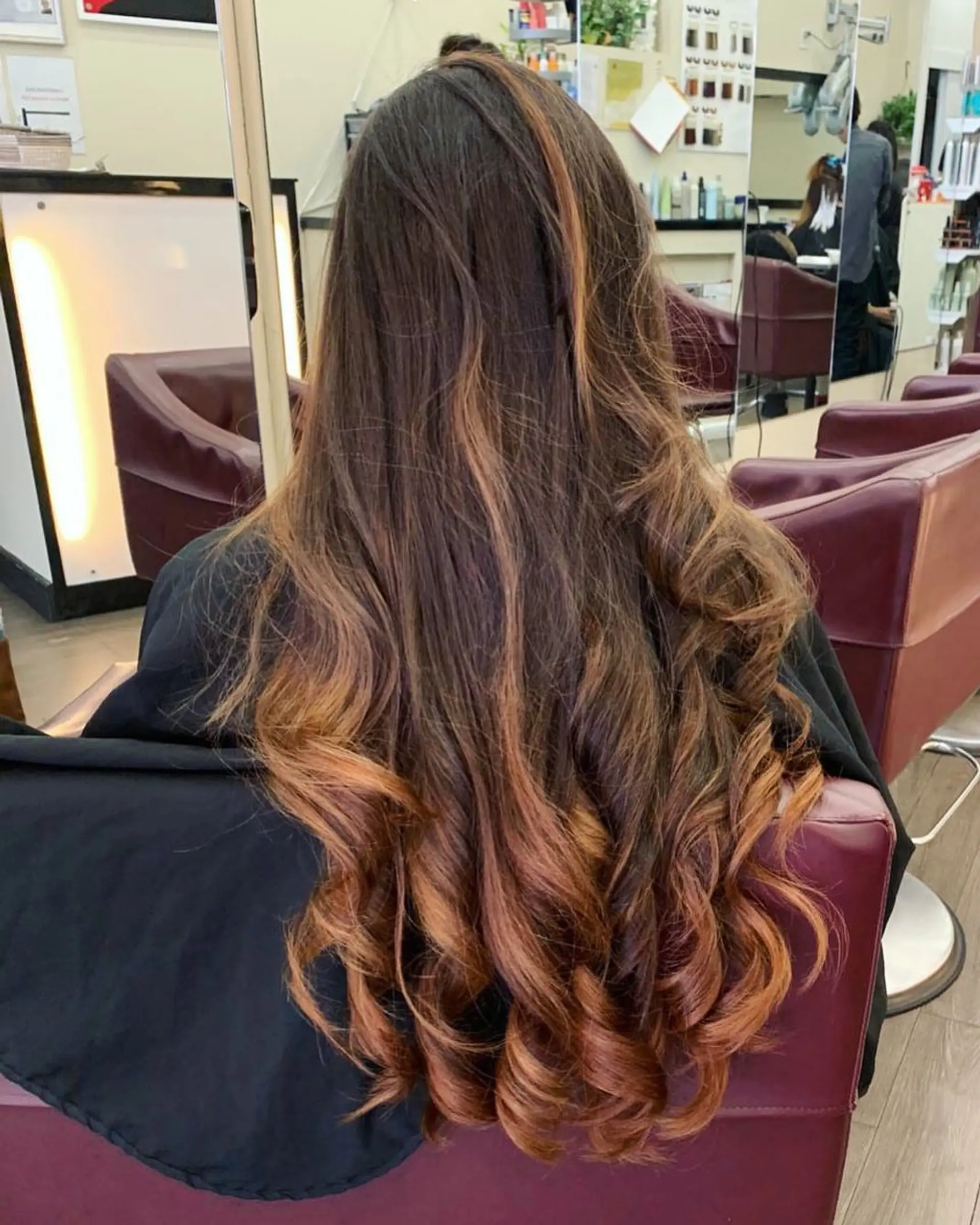 Long wavy hairstyle with brown and caramel balayage and curled ends. 1