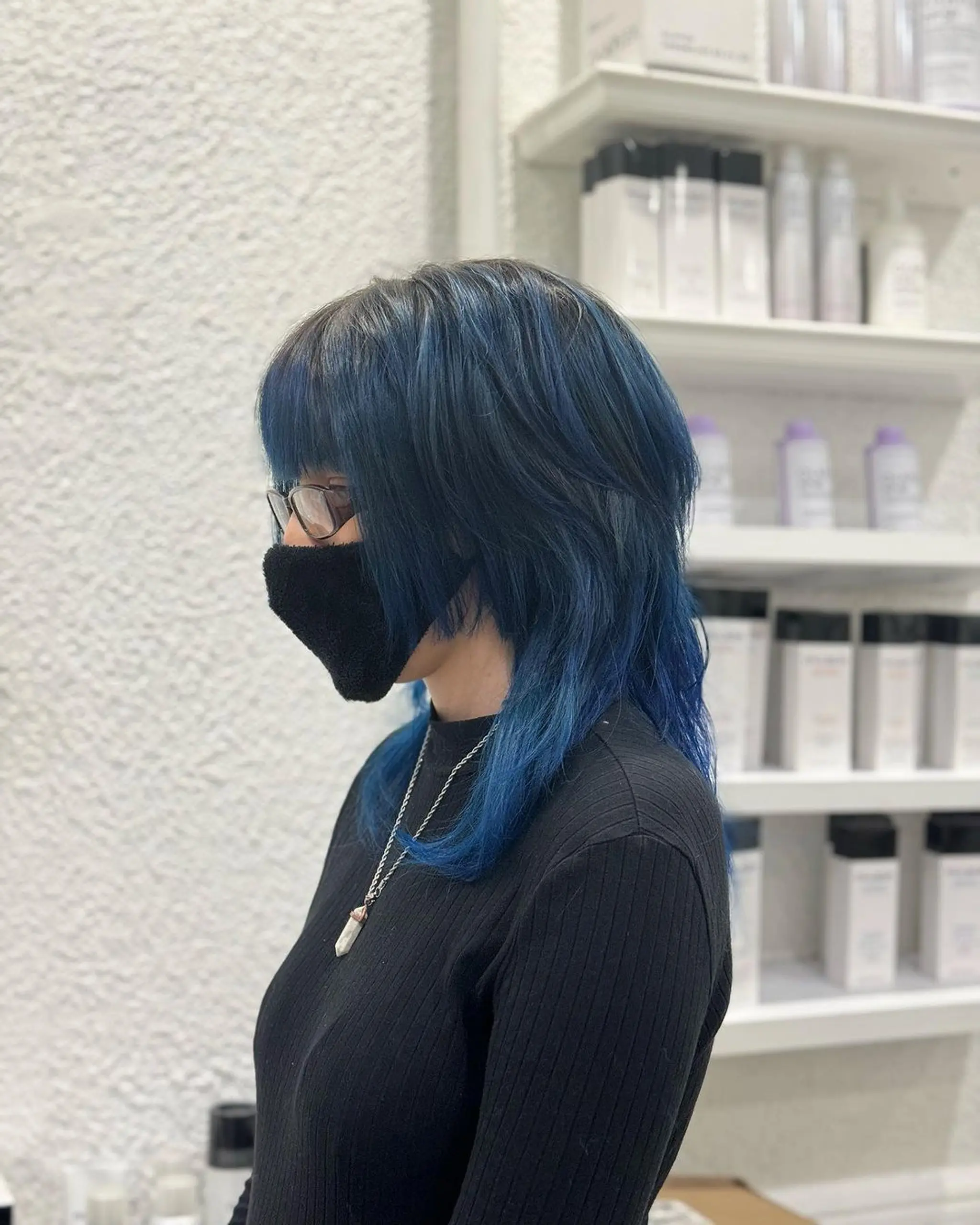 Straight, medium-length hair with layered, deep blue, and black colors. Features an edgy fringe and graduated layers for a voluminous and modern look. 1
