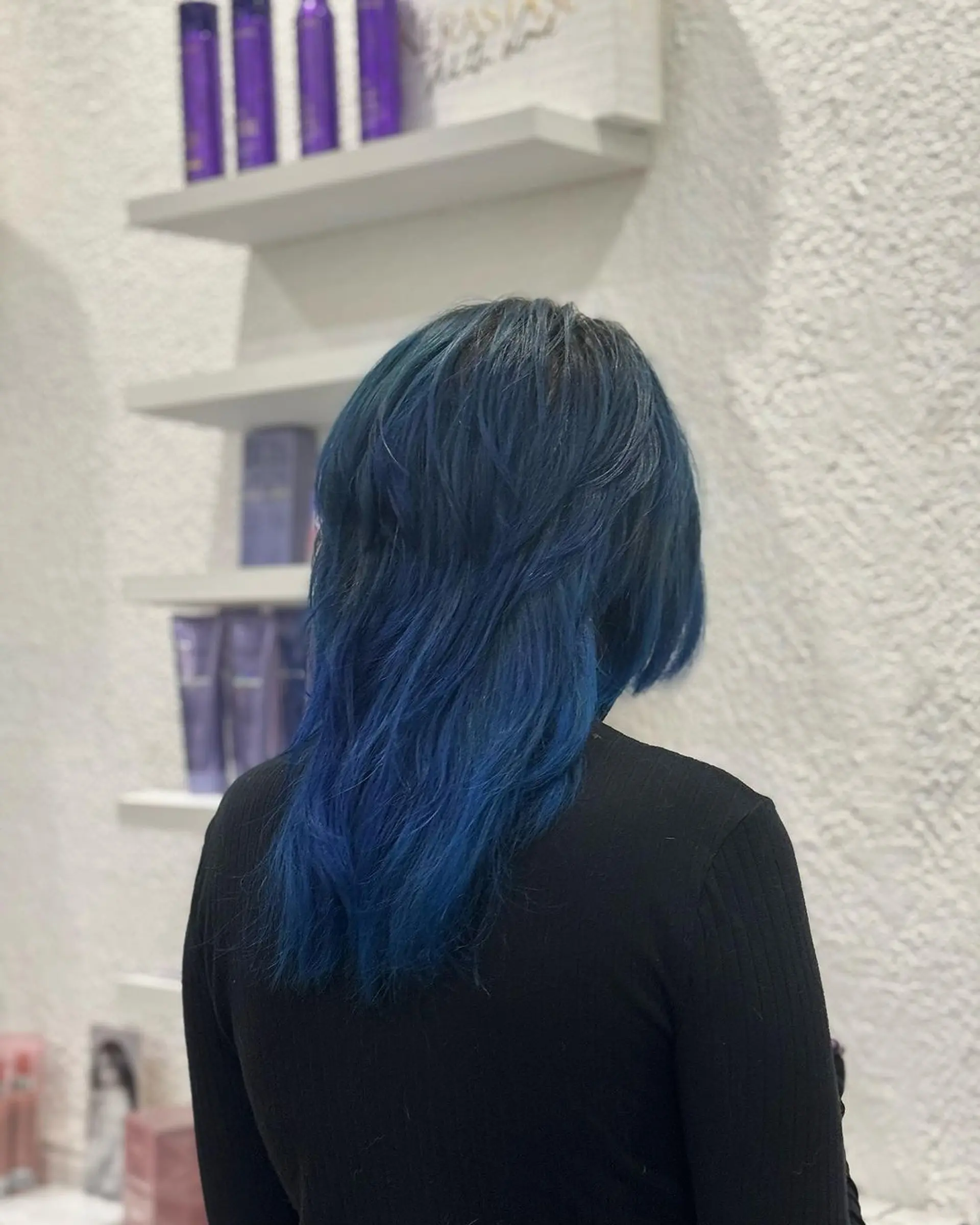 Straight, medium-length hair with layered, deep blue, and black colors. Features an edgy fringe and graduated layers for a voluminous and modern look. 2
