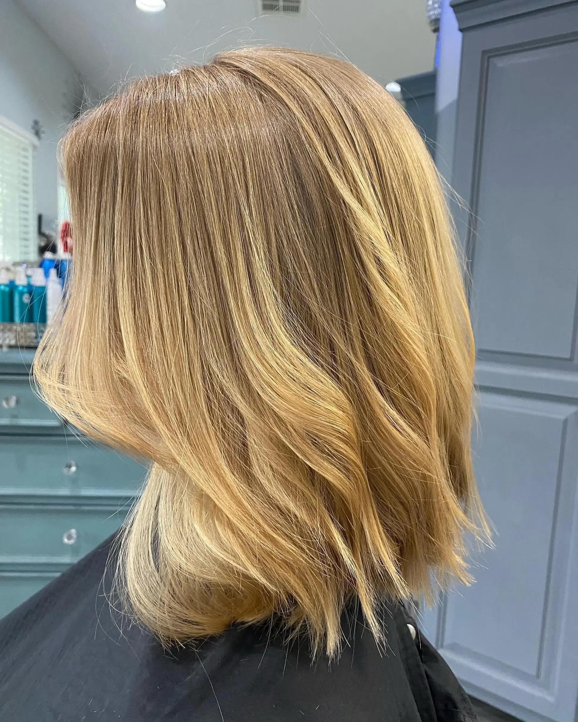 A textured shoulder-length golden blonde lob styled with soft dimension and subtle bends. 1