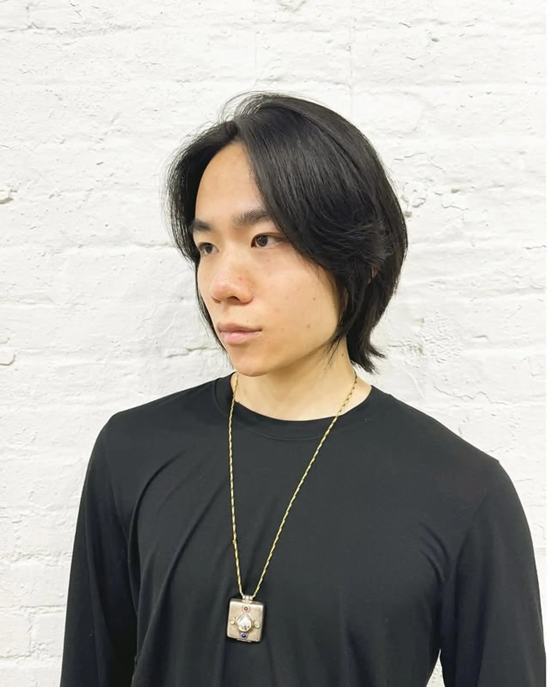 A medium length, layered haircut with curtain bangs and soft waves. 1