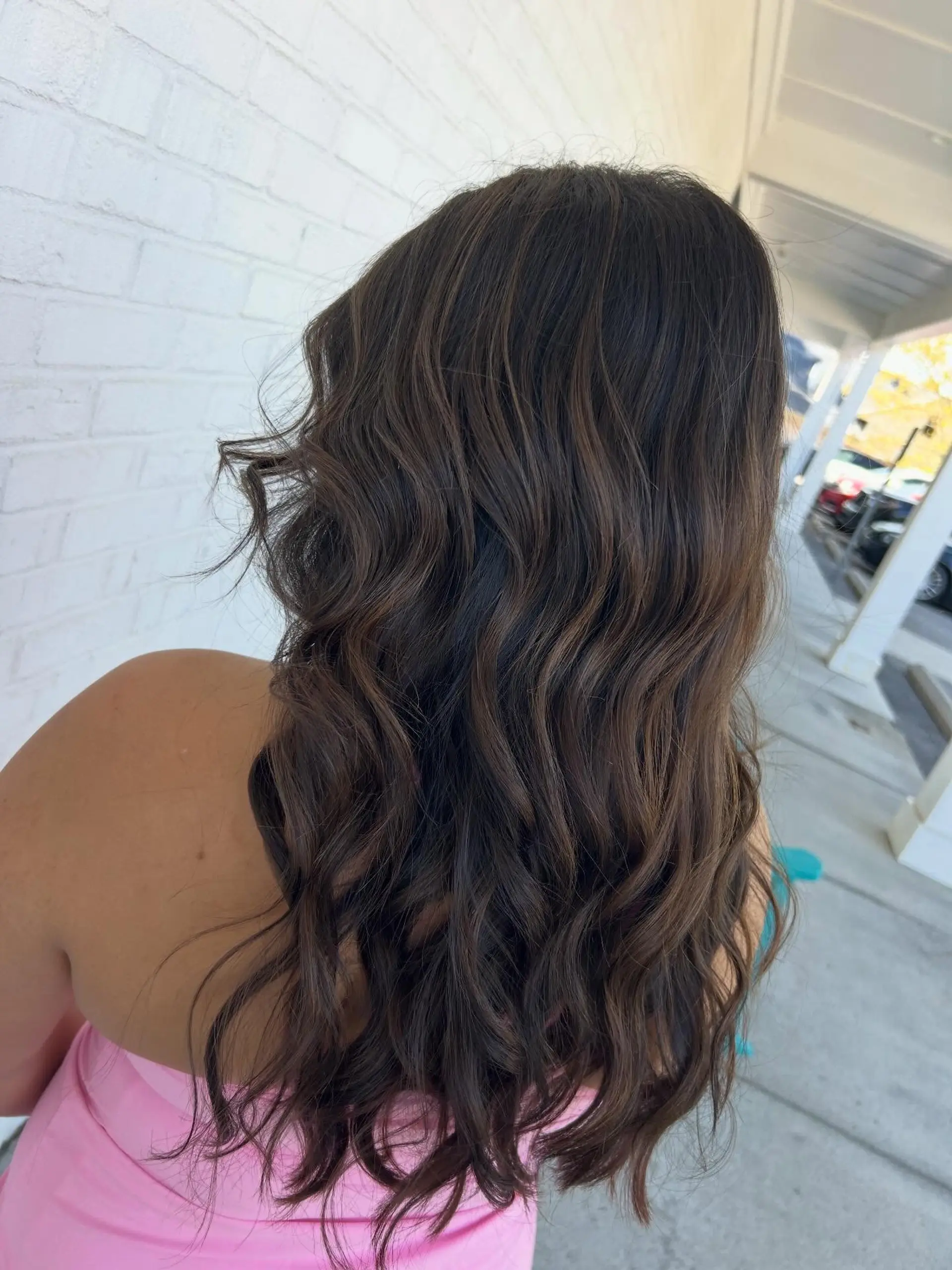 Long, flowing dimensional brunette hair styled in soft, relaxed waves. 1