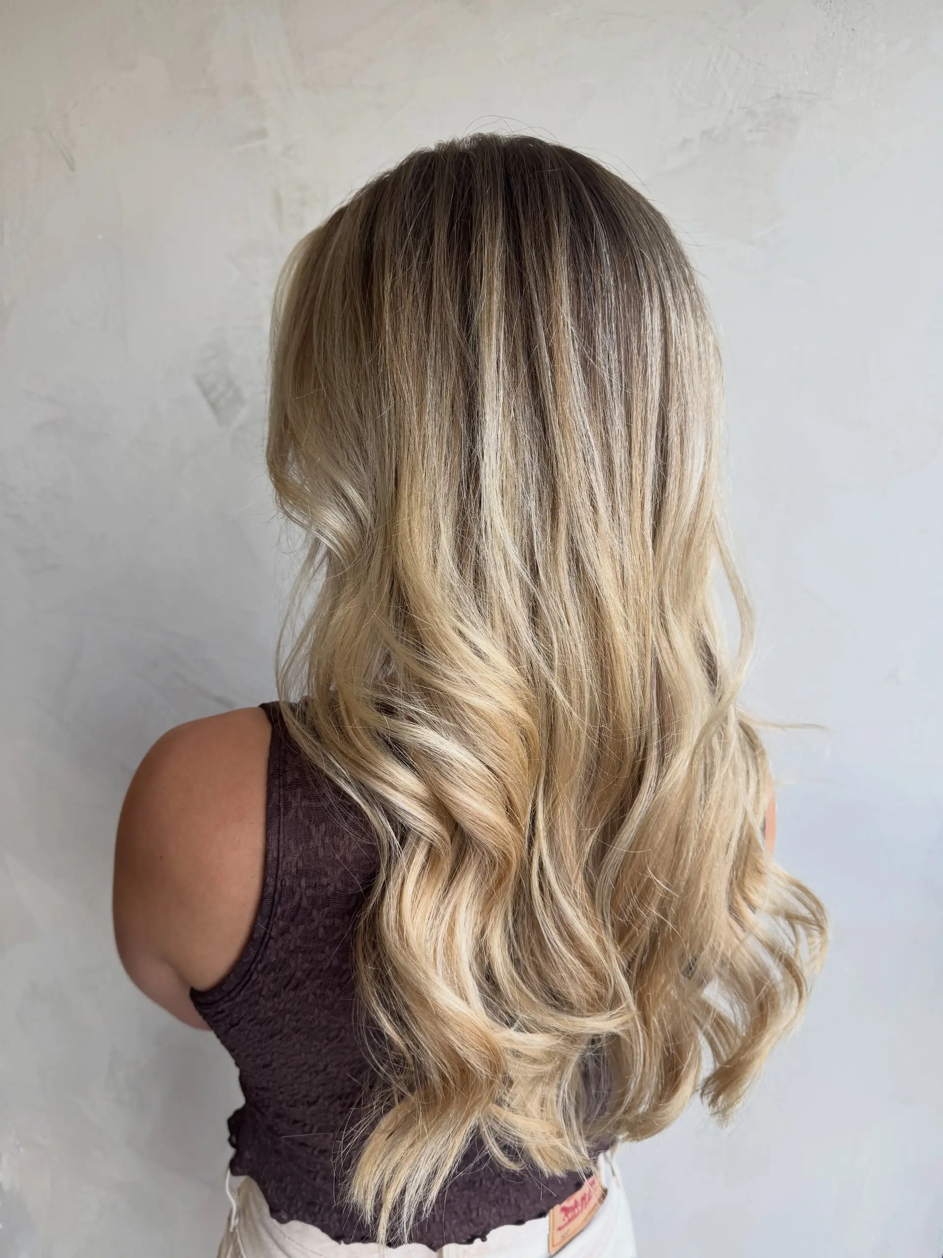 Long dimensional blonde hair with soft, seamless blending and styled in loose curls. 1