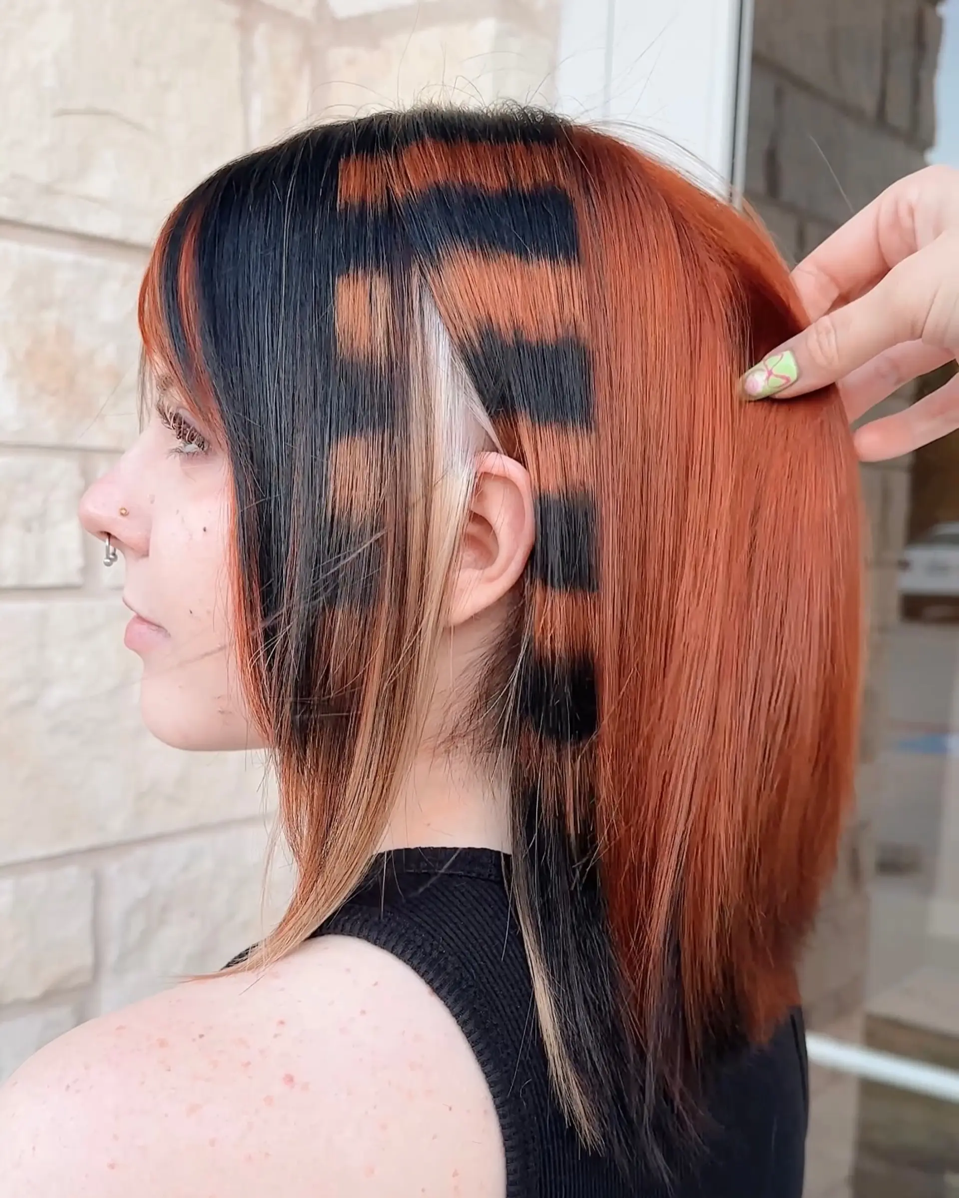This medium-length layered cut features dramatic fringe bangs and bold, contrasting color panels. The style includes vivid copper, chunky blonde highlights, and an intricate leopard print pattern on a darker hair base, creating a distinct alternative aesthetic. 2