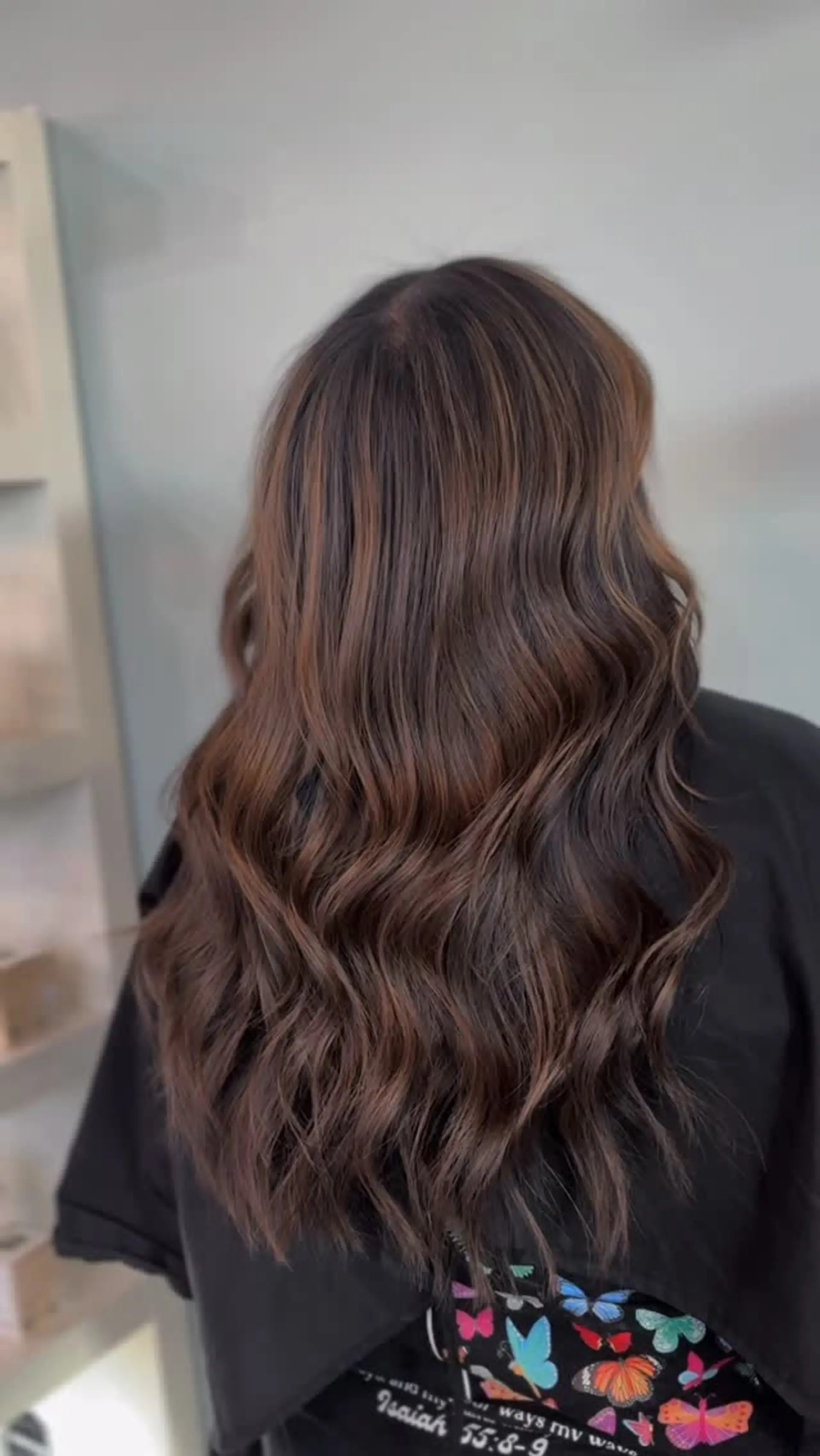 Long dark brown hair enhanced with subtle chocolate balayage highlights and styled in soft, cascading waves. 1