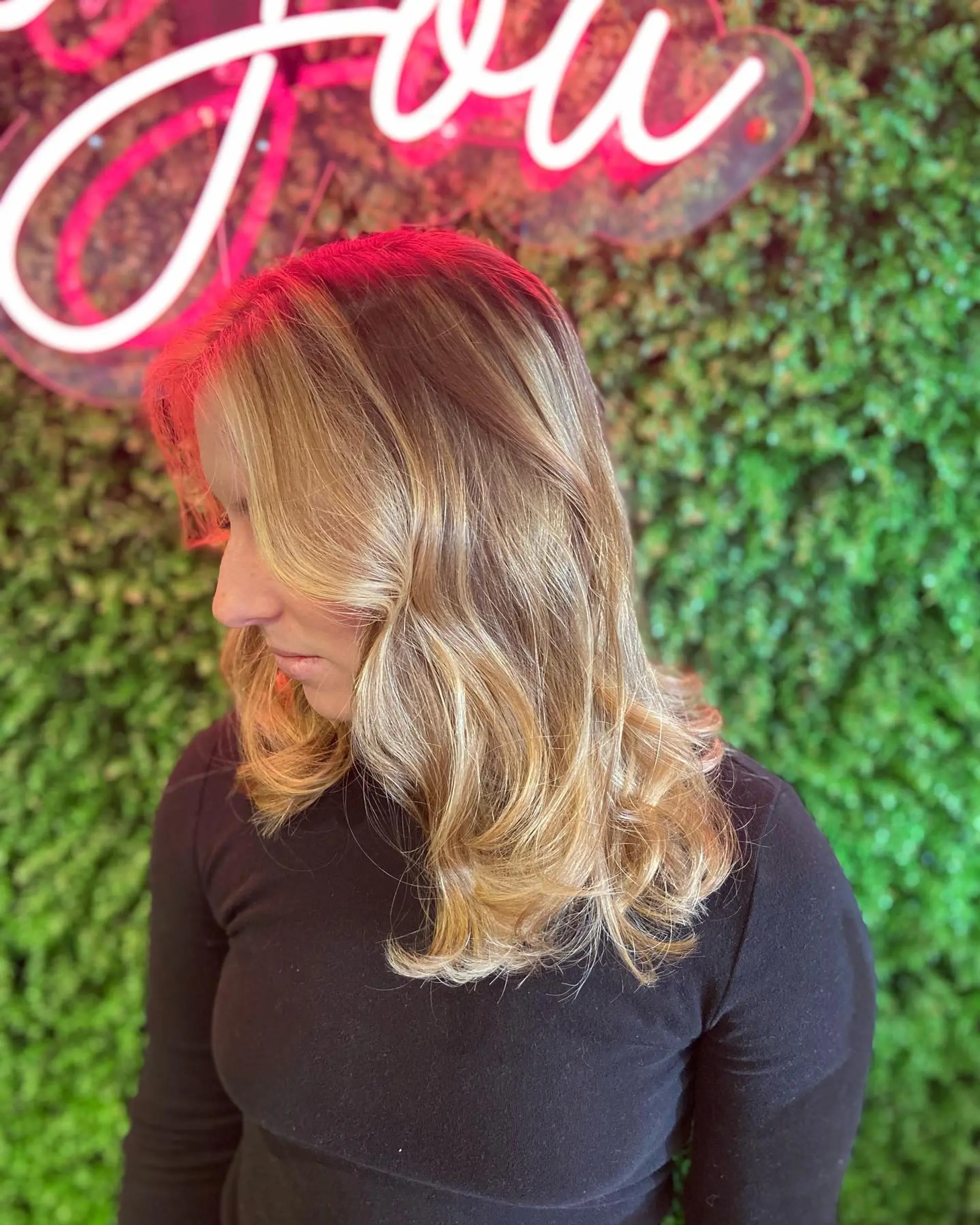 Medium-length lived-in golden blonde balayage with soft face-framing waves and flipped ends. 1