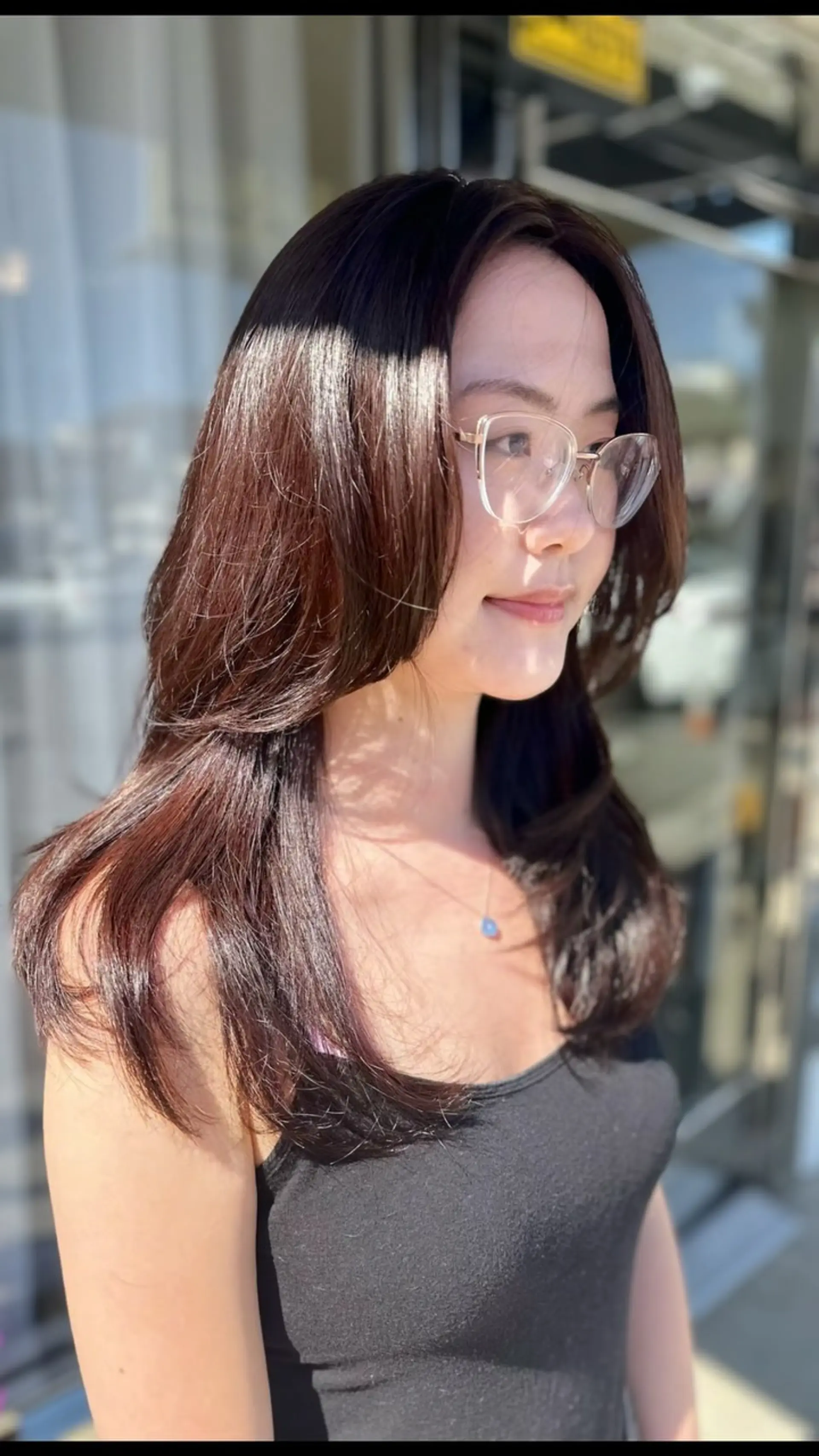 A long layered cut with soft, curved face-framing layers colored in a glossy cool brown tone. 1