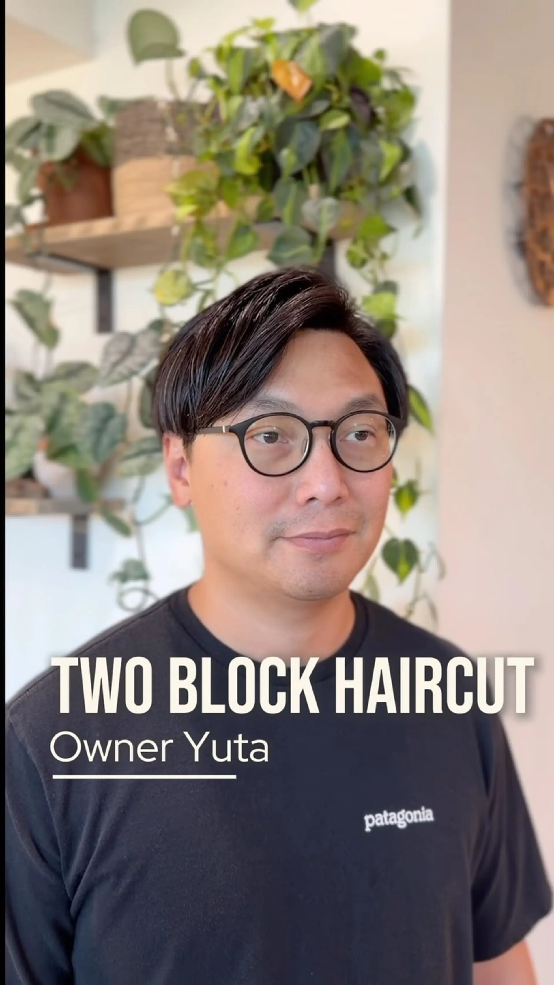 A clean, modern two-block haircut featuring undercut sides and a longer, side-swept textured top. 1