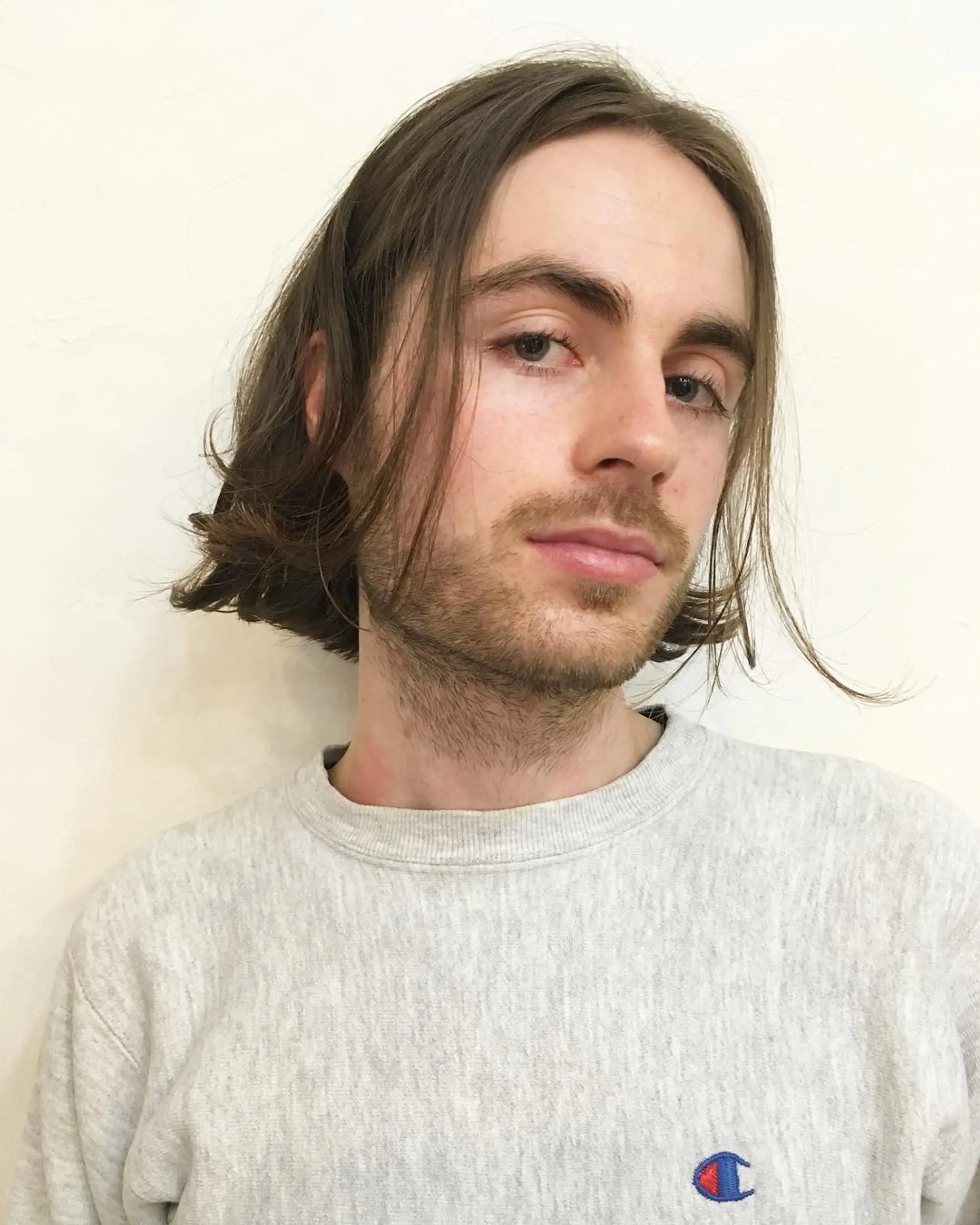 Medium length, straight hair with a natural middle parting. The ends are slightly tousled and the hair appears relaxed and effortless.