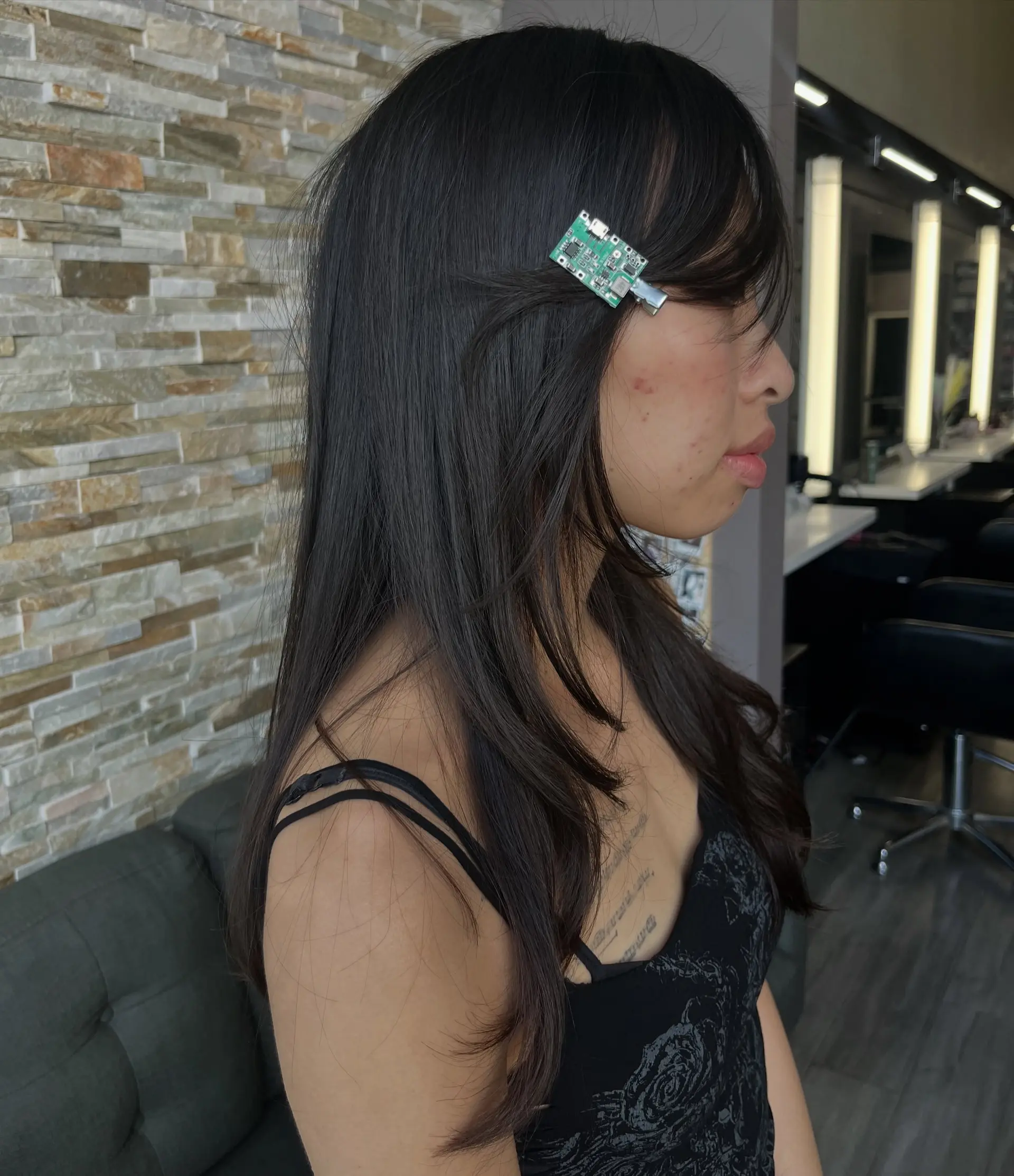 Straight dark hair featuring soft face-framing pieces, long subtle layers, and a side-swept bang. 1