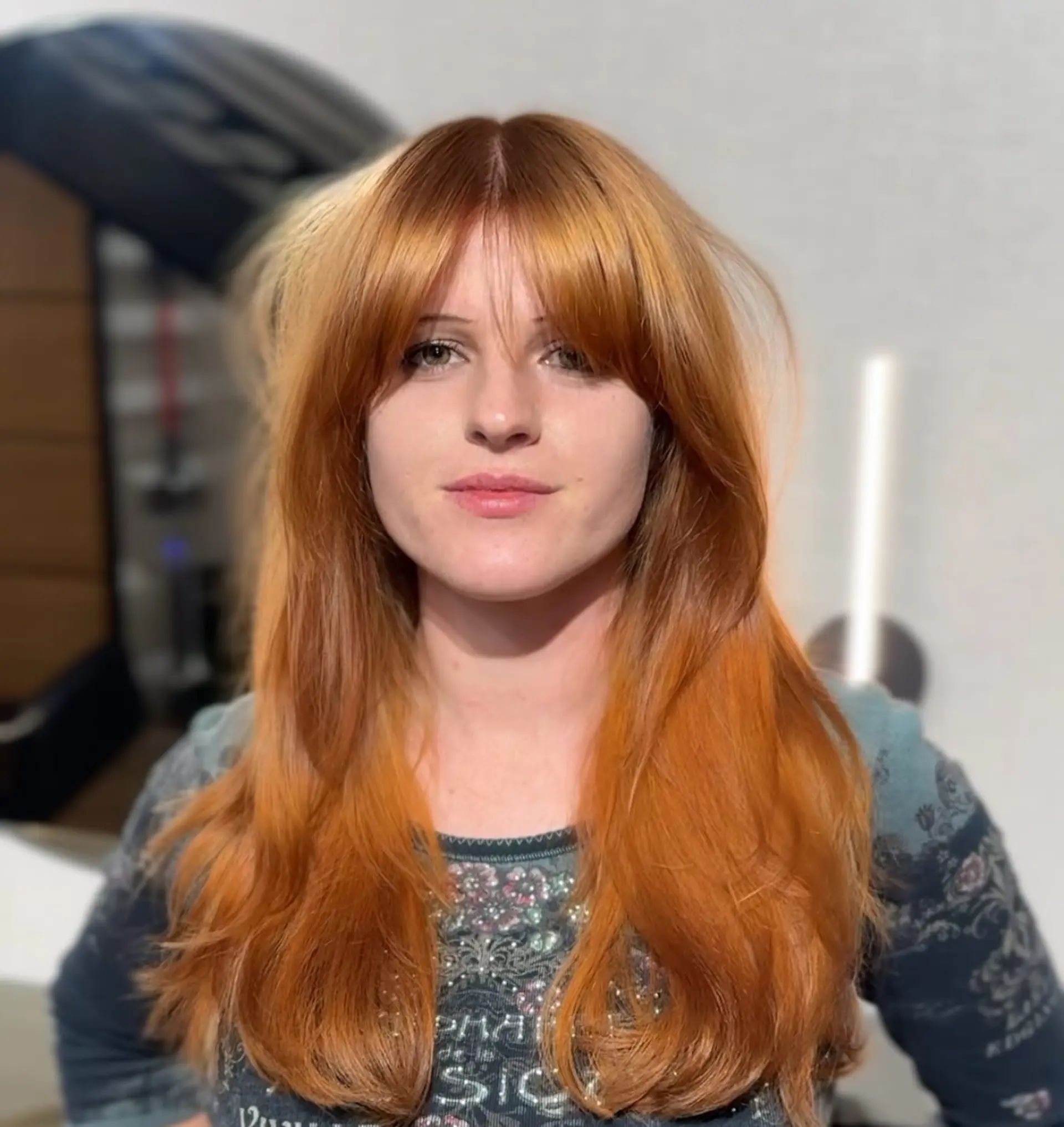 A voluminous long layered haircut featuring center-parted curtain bangs that sweep outwards to frame the cheekbones, complemented by feathered, rounded ends. 1