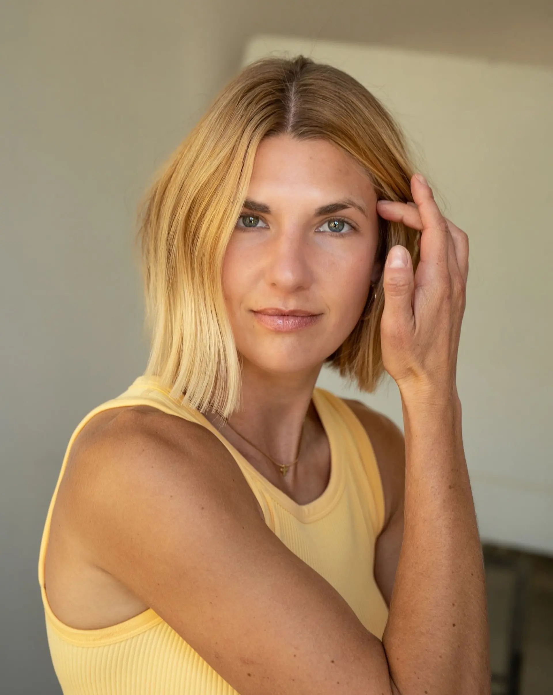 A chin-grazing soft blunt bob in warm golden blonde, styled straight with natural texture. 1