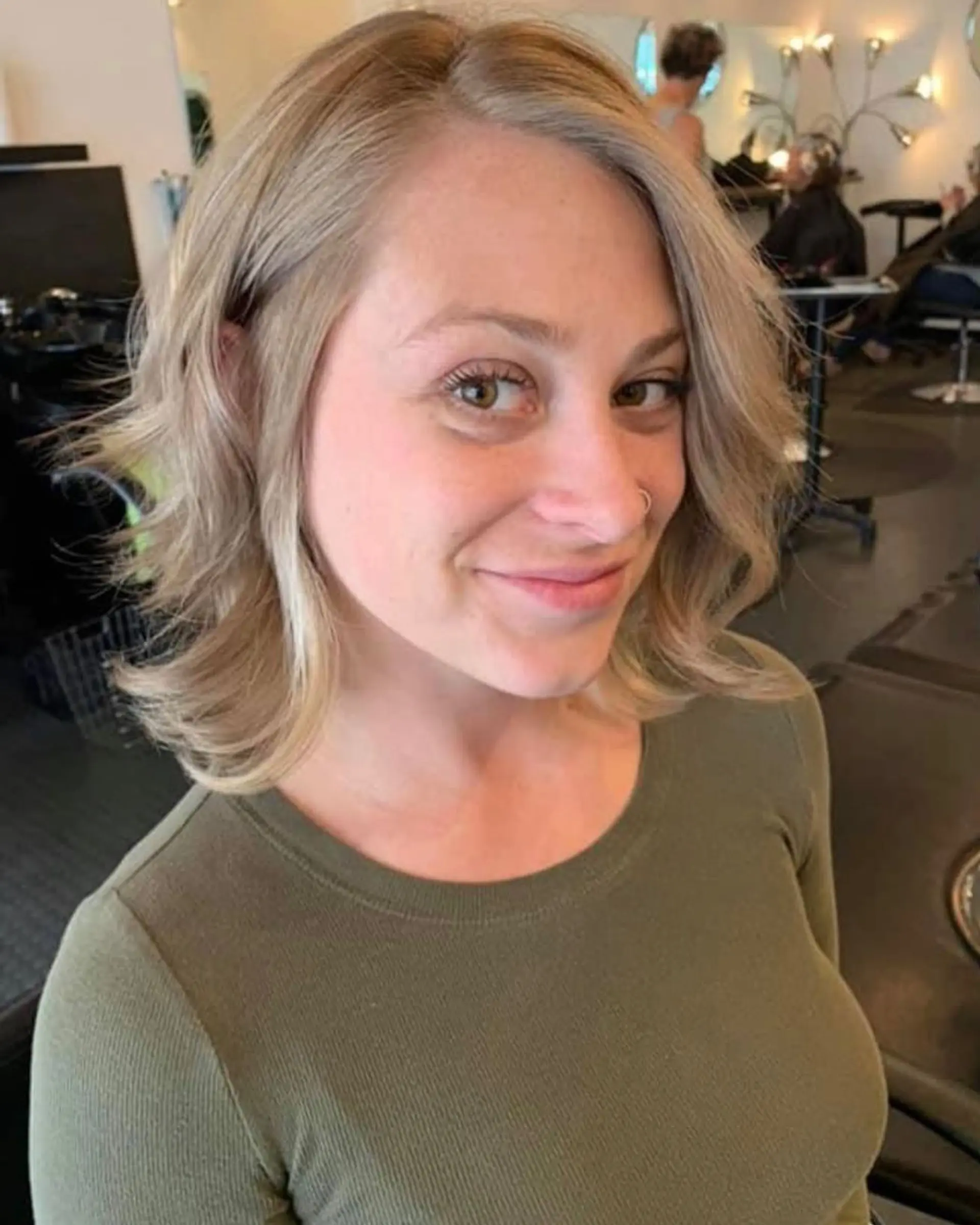 A textured, shoulder-length blonde lob styled with soft waves and bright face-framing highlights. 1