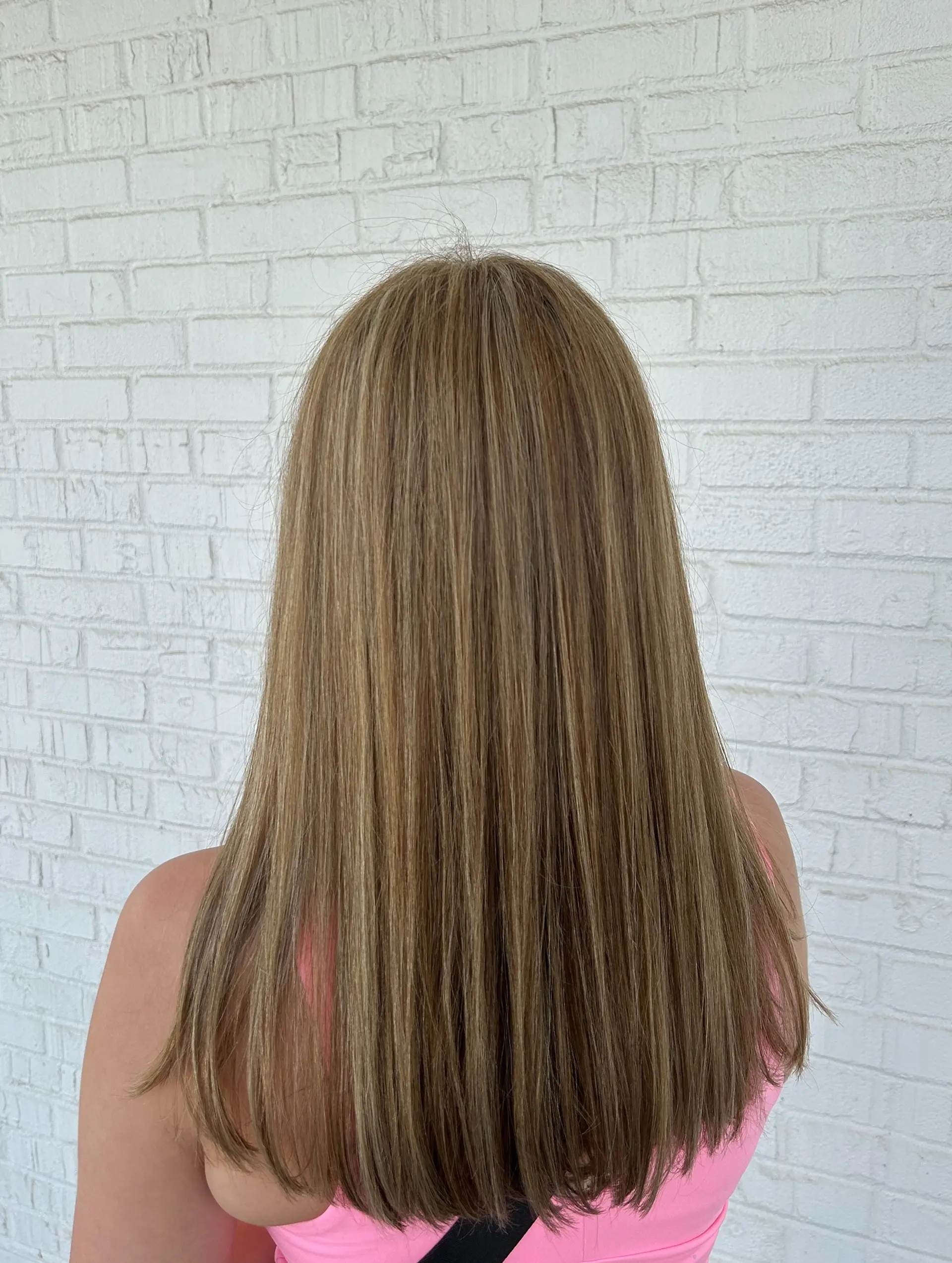 Long, sleek straight hair featuring finely blended warm honey blonde highlights over a light brown base. 1