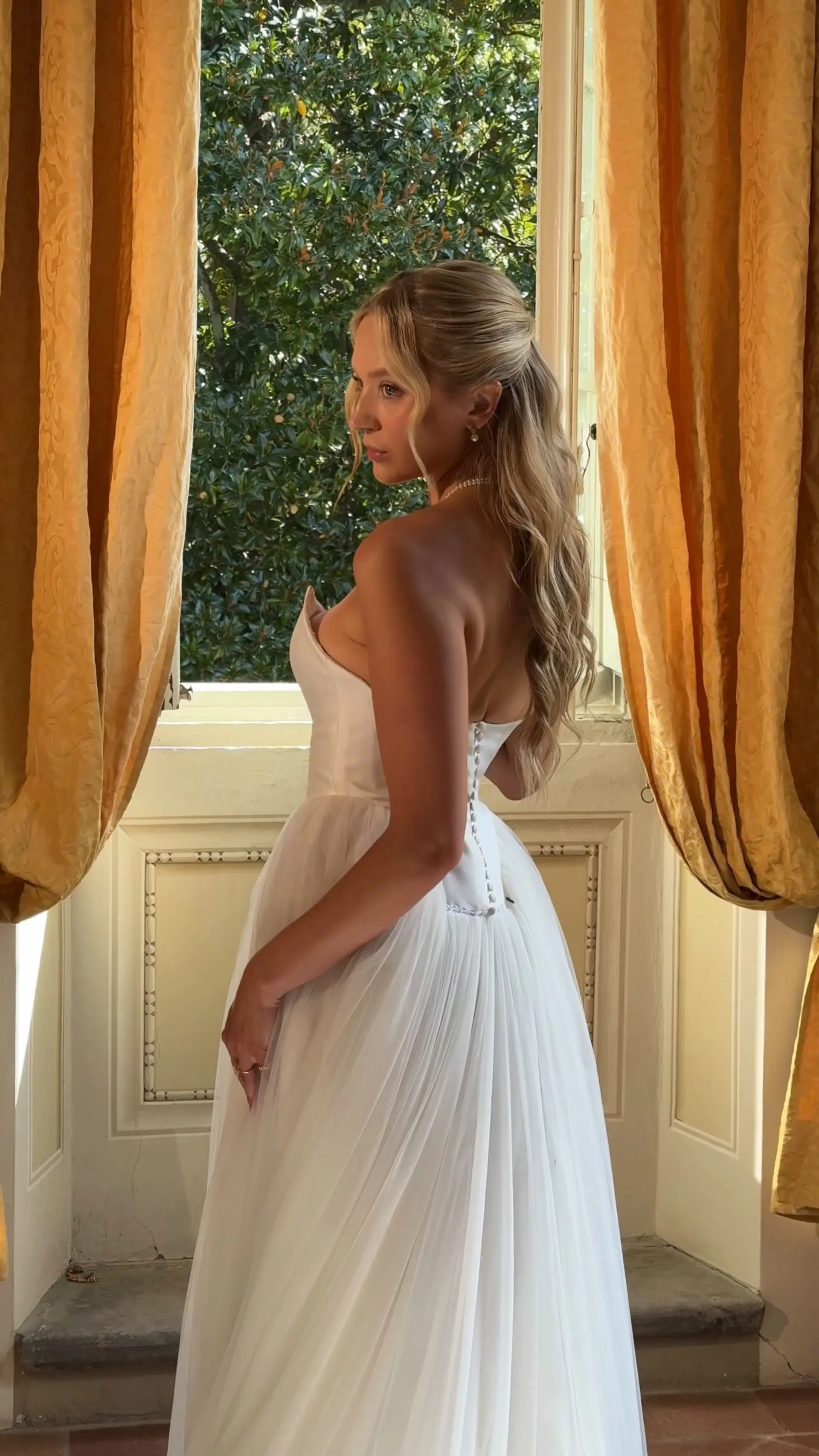 Romantic long champagne blonde hair styled in a half-up bridal look with soft textured waves and face-framing strands. 1
