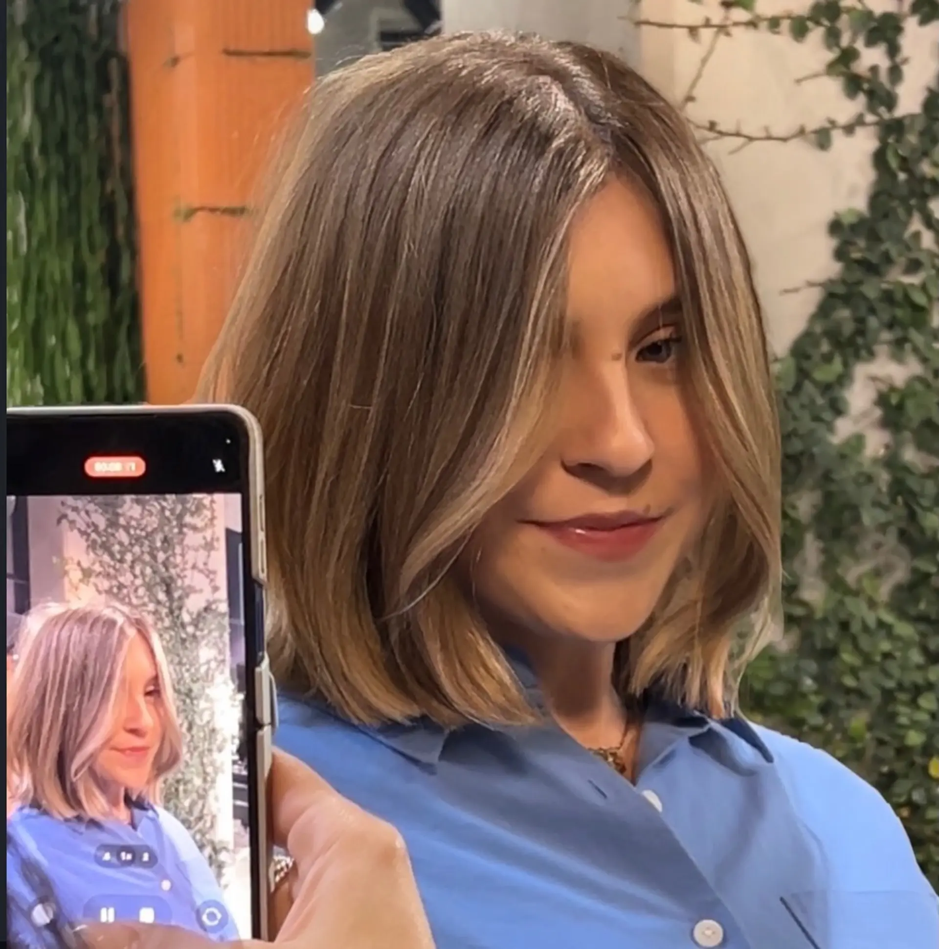 A sleek, collarbone-length bob with soft face-framing layers and warm blonde balayage highlights. 1