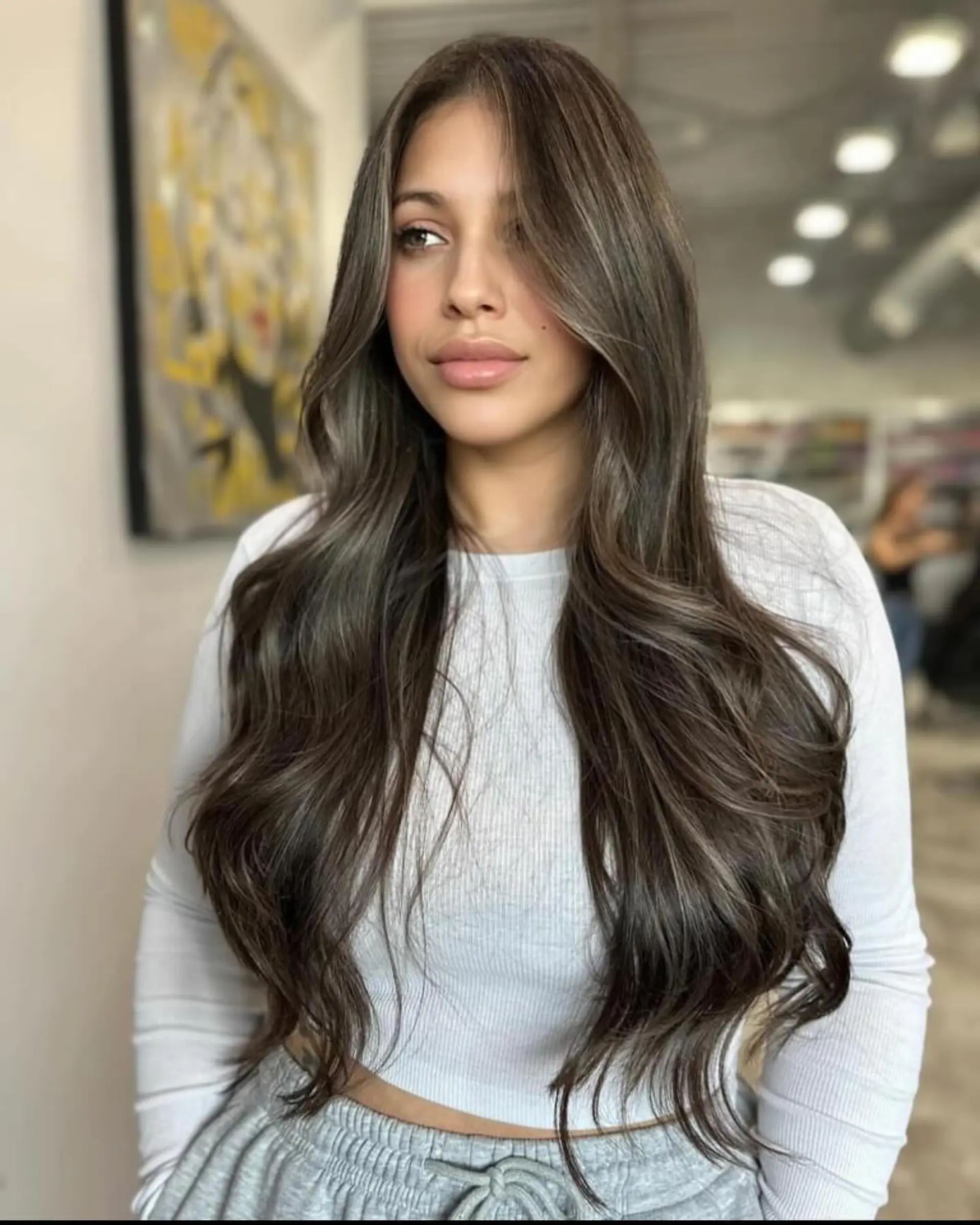 Long, layered, wavy hair with face-framing layers and a bronde balayage. 1