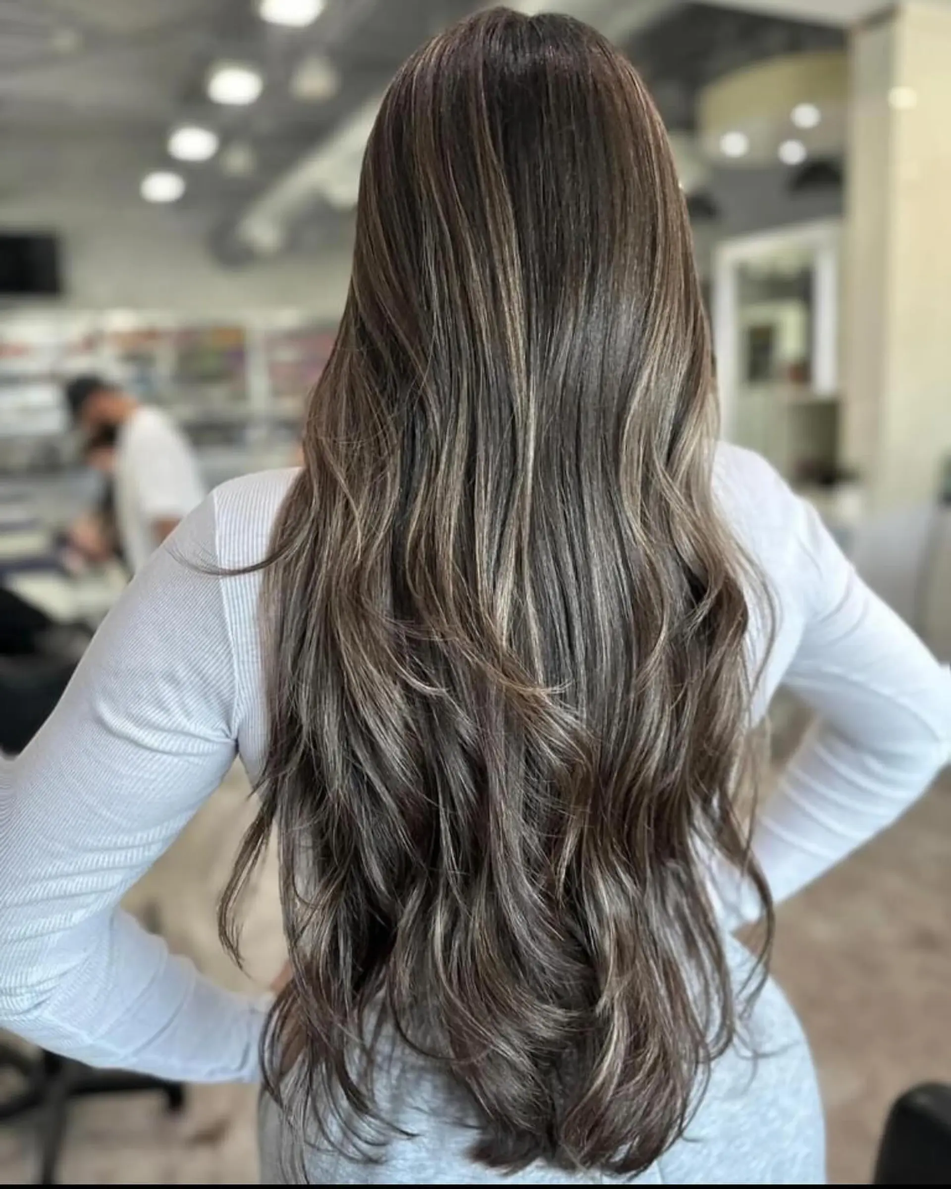 Long, layered, wavy hair with face-framing layers and a bronde balayage. 2