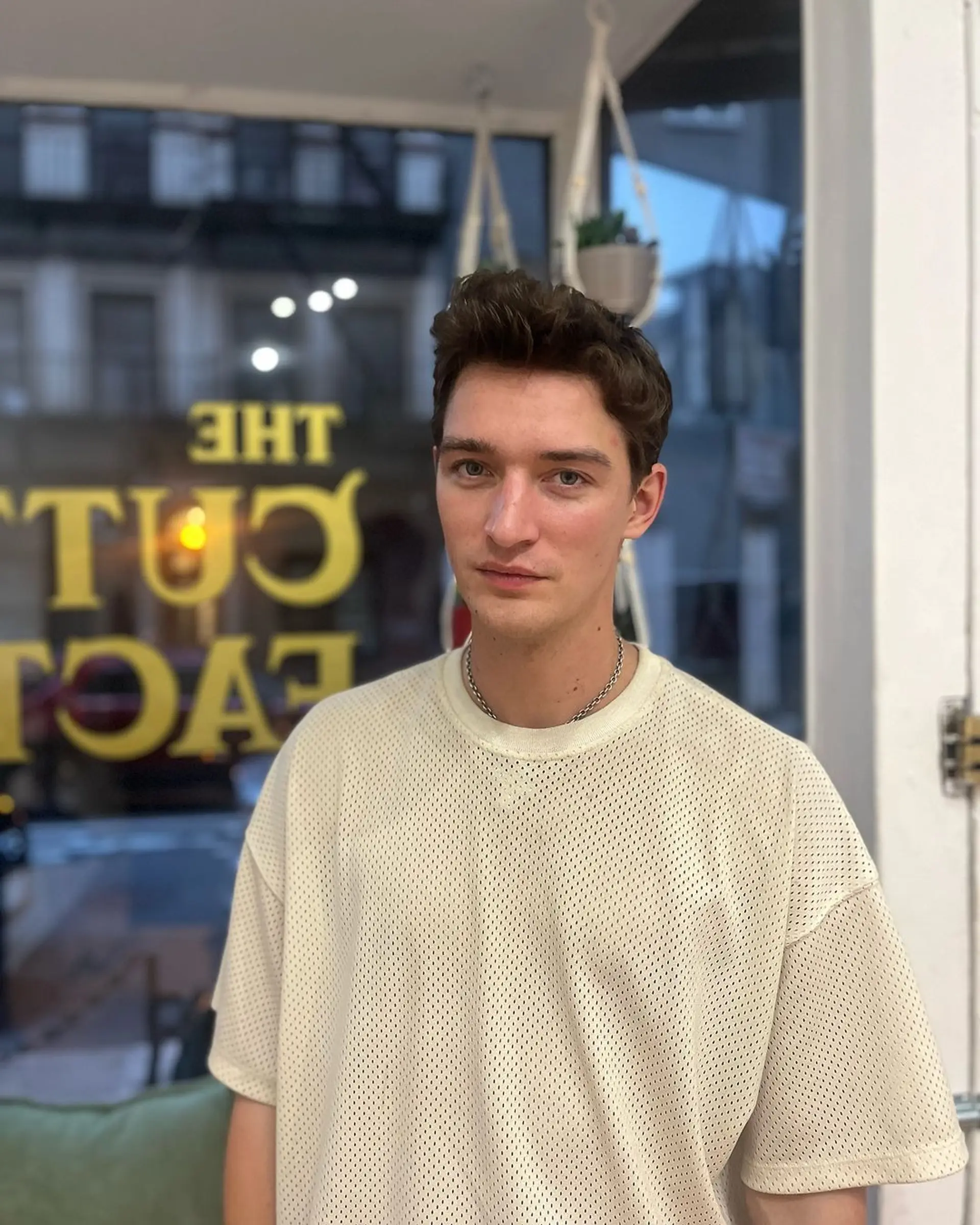 Short, straight, brown hair styled into a casual, windswept look with a laid-back, tousled appearance. 1