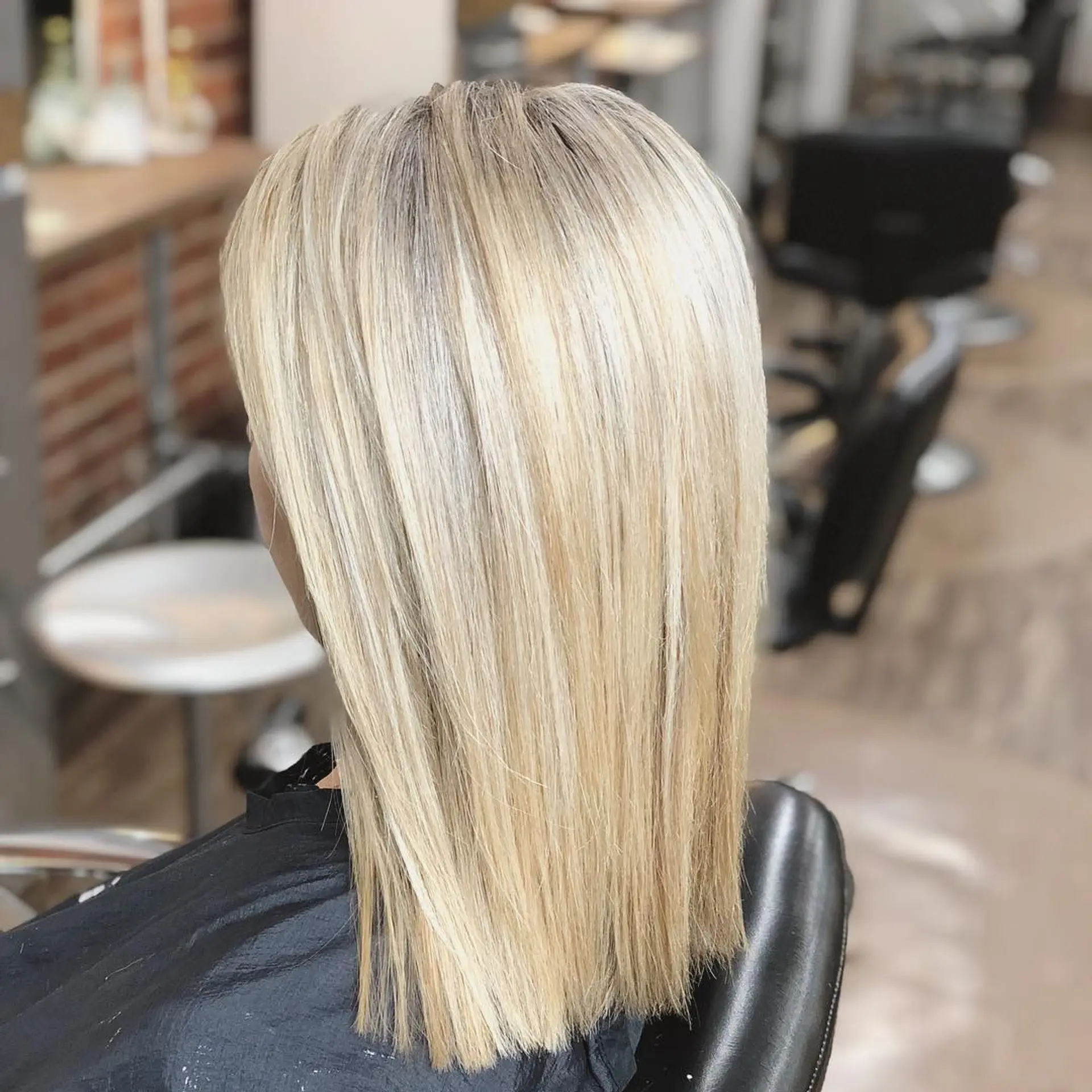 Straight shoulder-skimming blonde hair styled smooth with fine, multi-dimensional balayage highlights and a blunt edge. 1