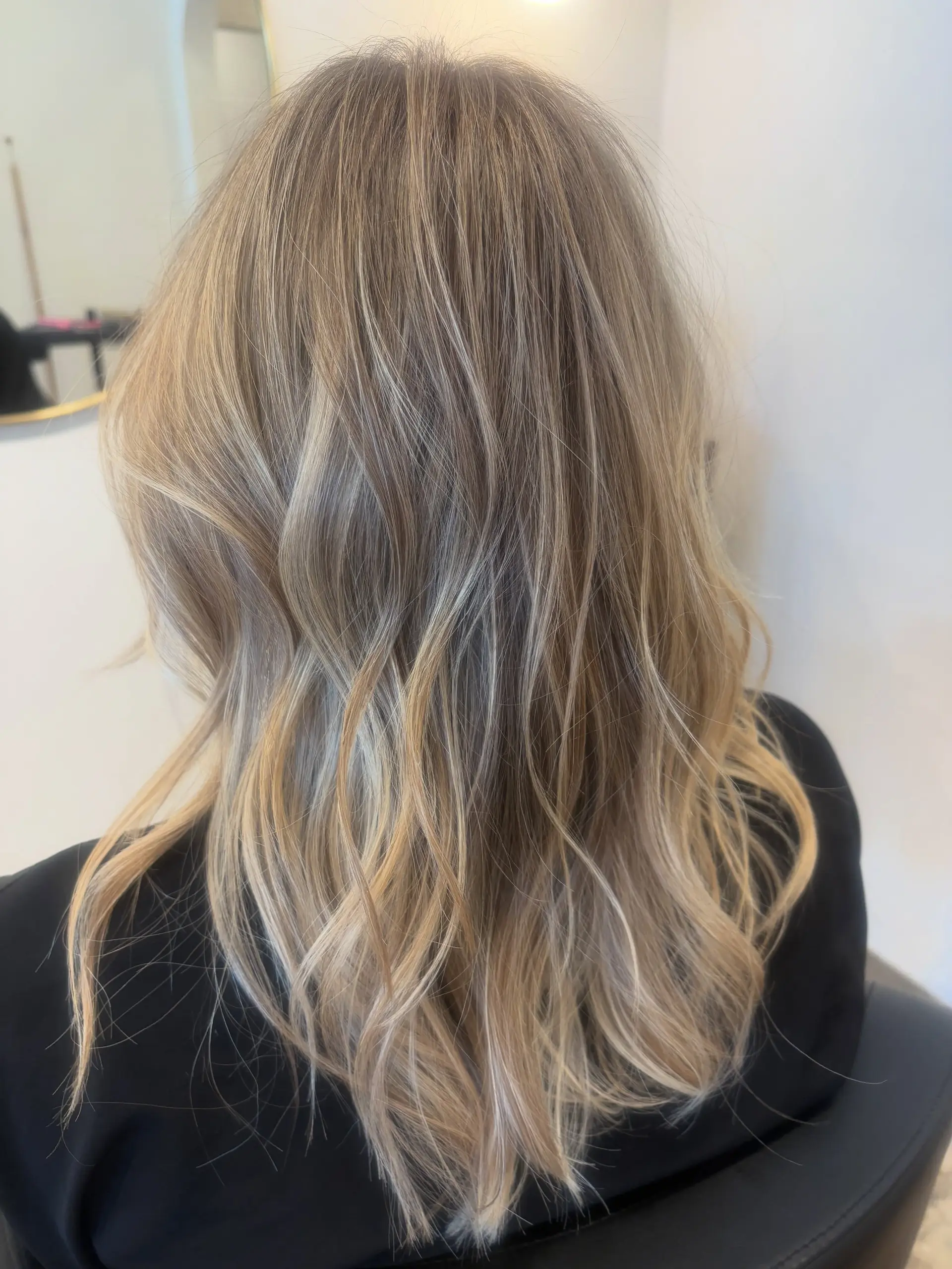 Medium-length dimensional blonde hair with multi-tonal highlights styled in soft, loose waves. 1