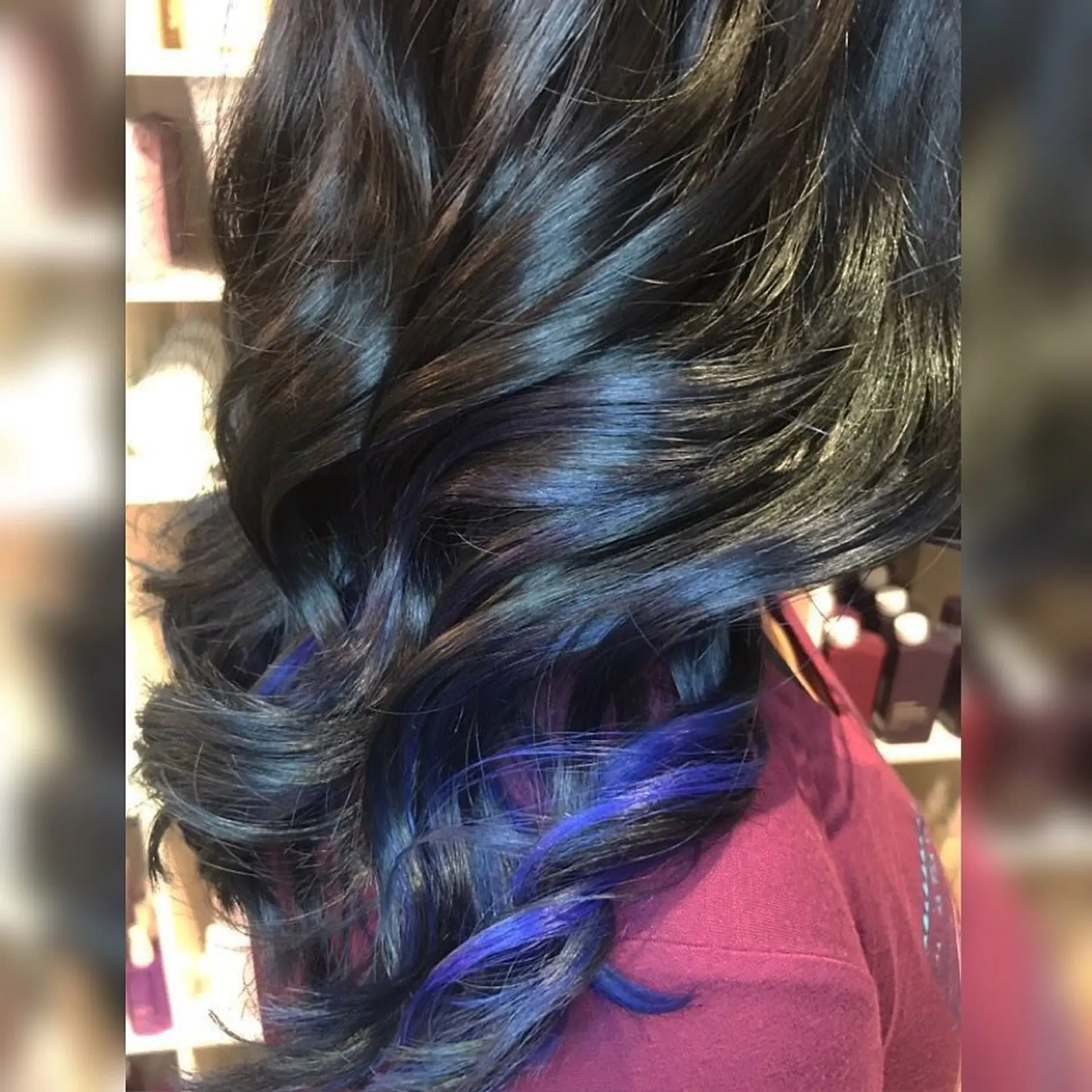 Glossy black hair styled into polished barrel curls with bright blue peekaboo highlights emerging from underneath. 1