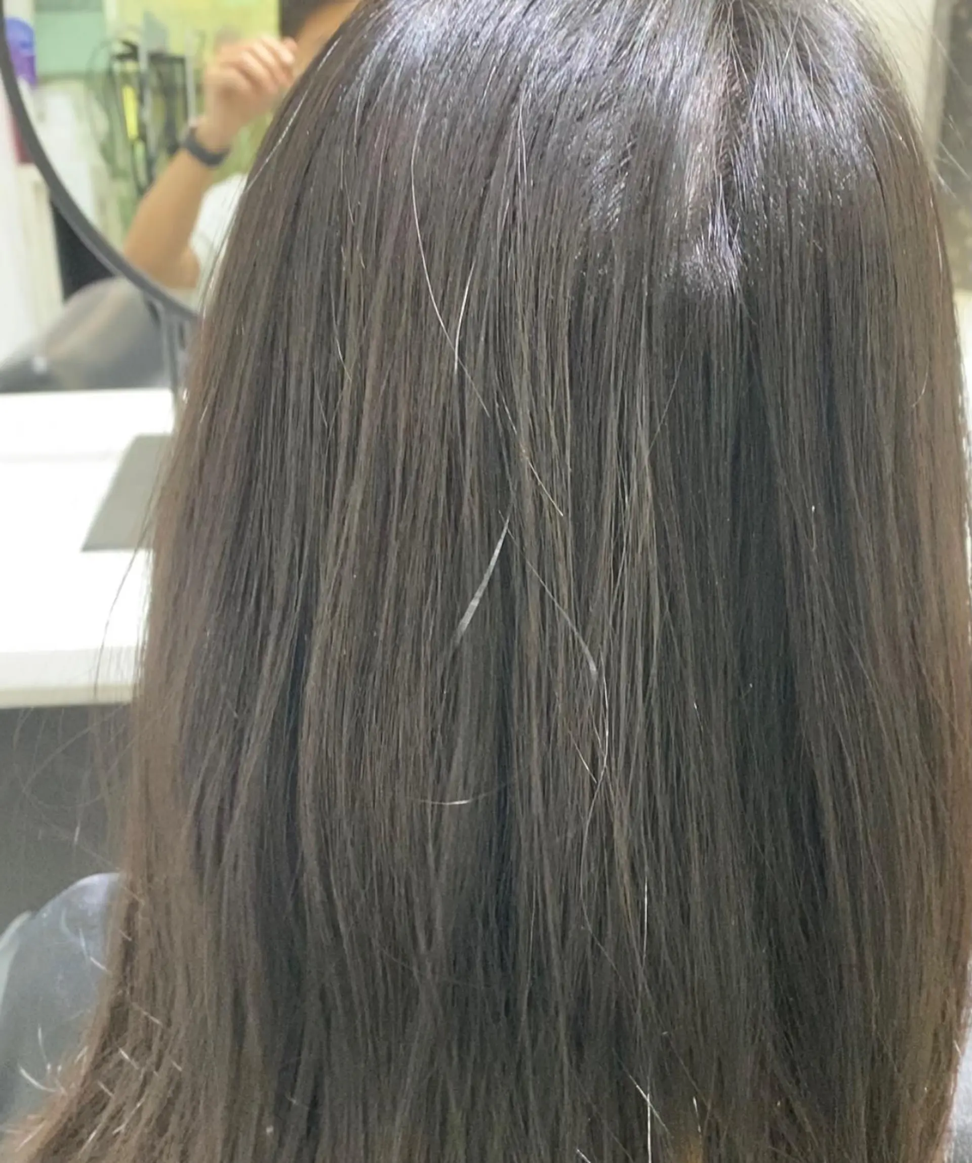 This hairstyle features medium-length, straight brunette hair with strategically placed silver highlights creating a subtle, modern look. 3