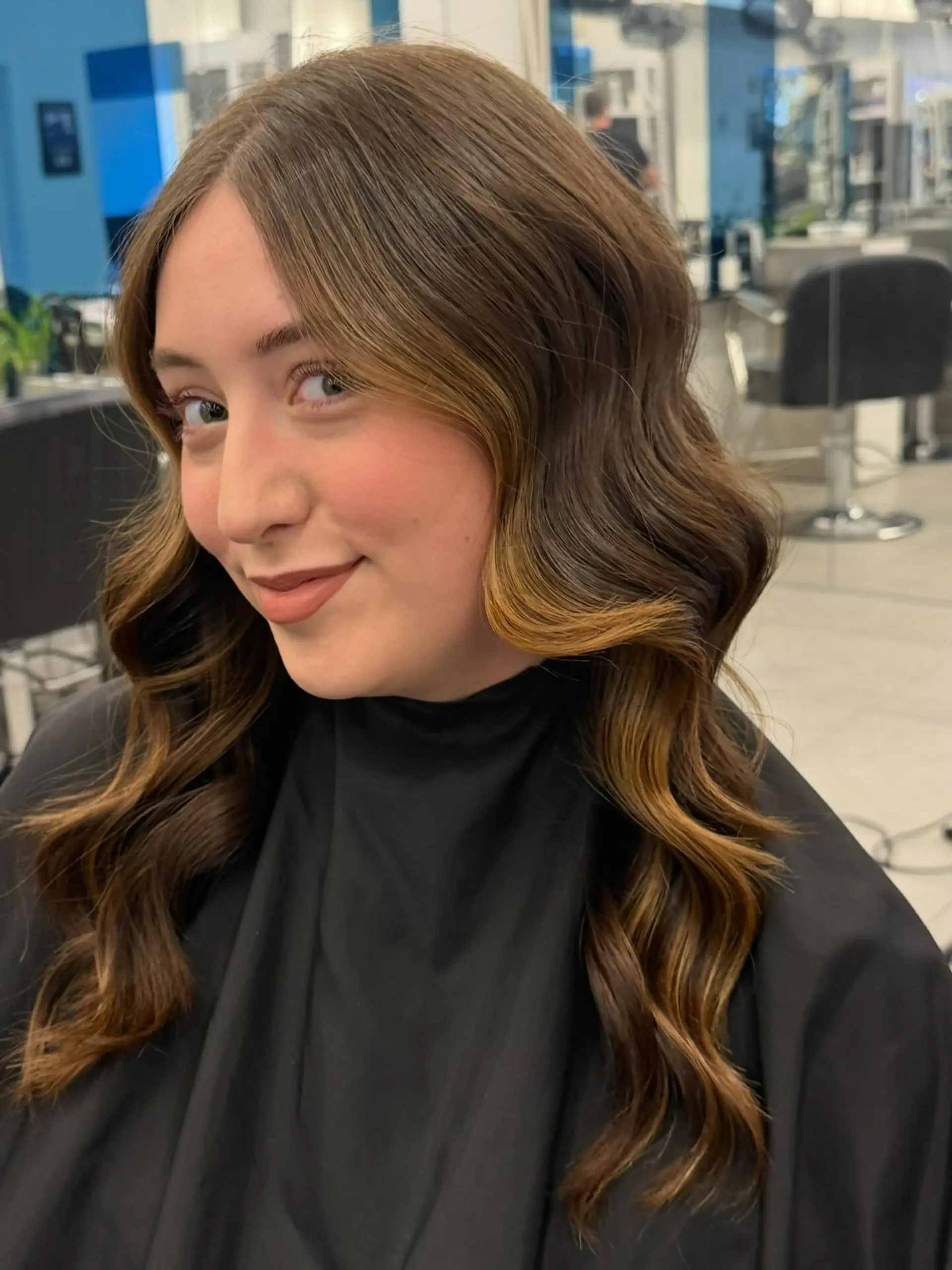 Long brown hair with soft waves and subtle caramel face-framing highlights. 1