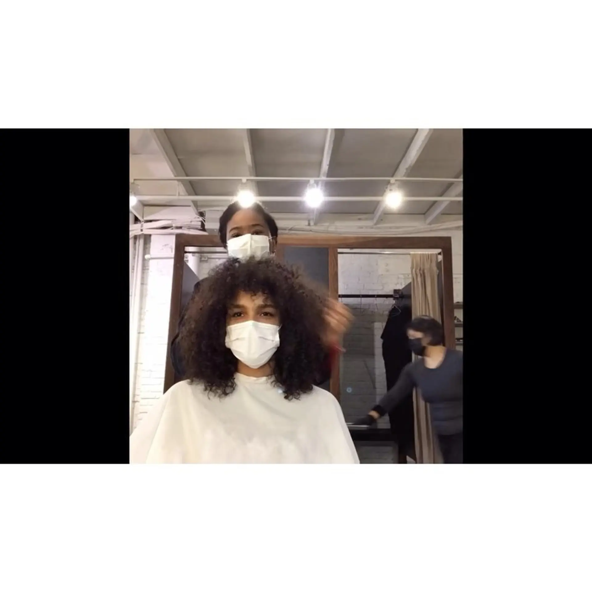 Medium-length rounded curly haircut featuring textured layers and soft curly bangs. 1
