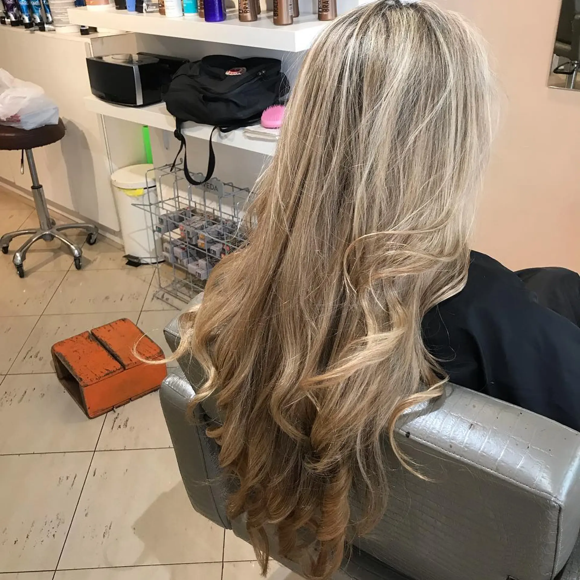 Long, wavy hair with a golden blonde balayage and layered cut. 1