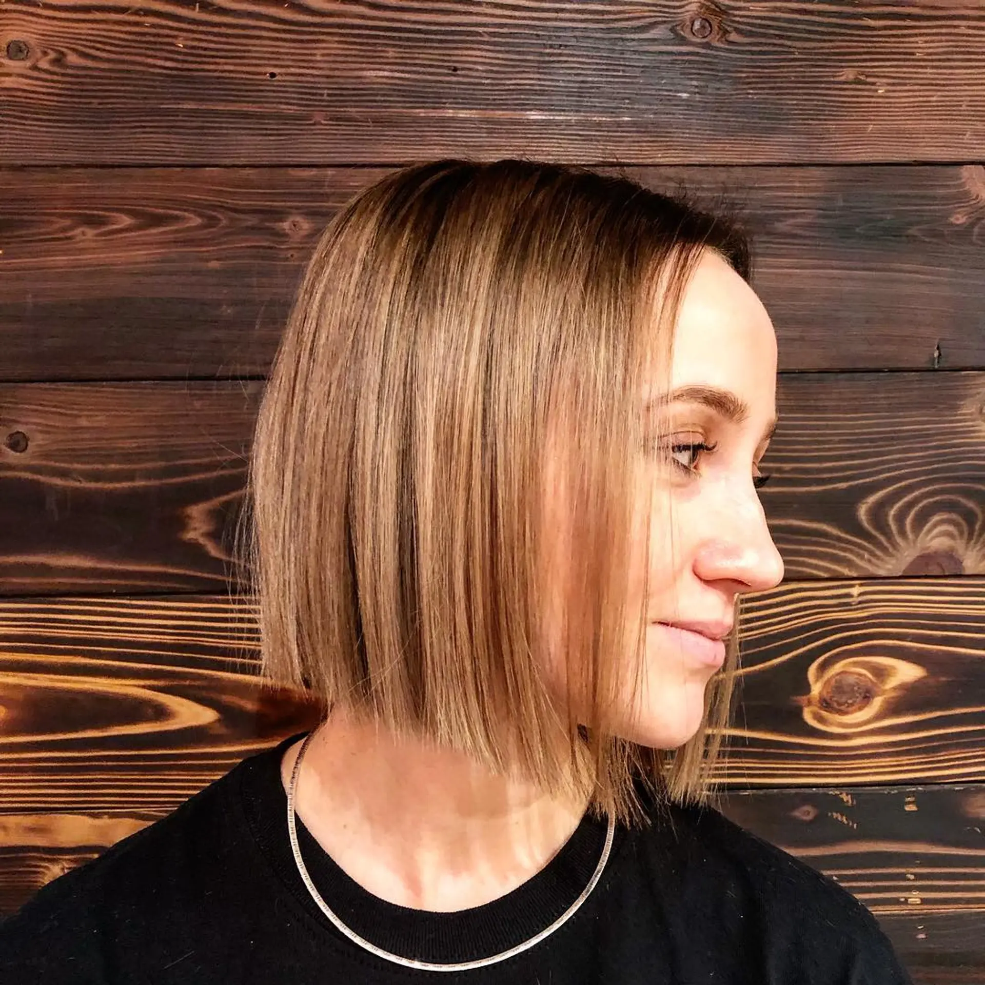 A short, blunt bob haircut with subtle caramel highlights. 1