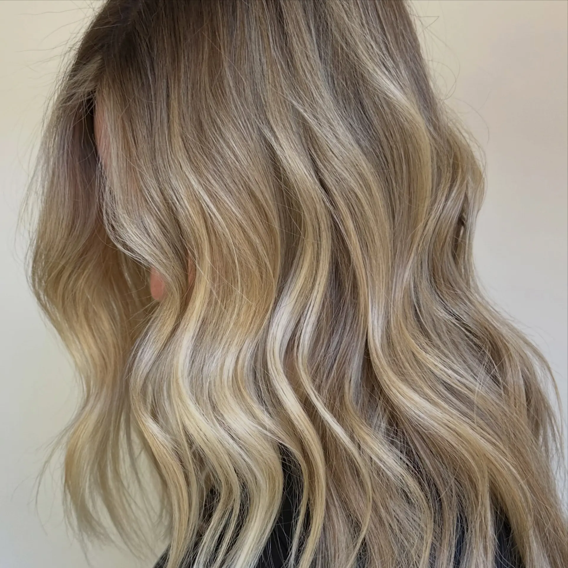 Lived-in blonde balayage with a blended root melt and soft, textured waves. 1