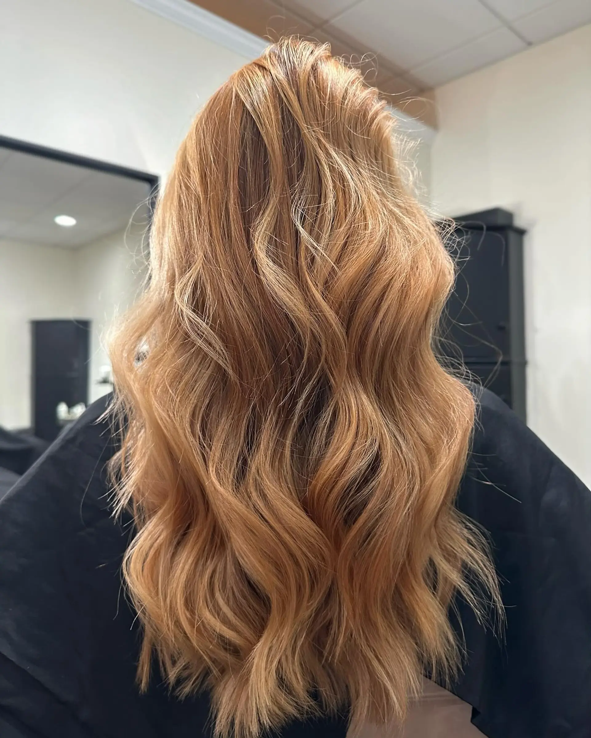 Long, luminous strawberry blonde hair styled in flowing, voluminous textured waves. 1
