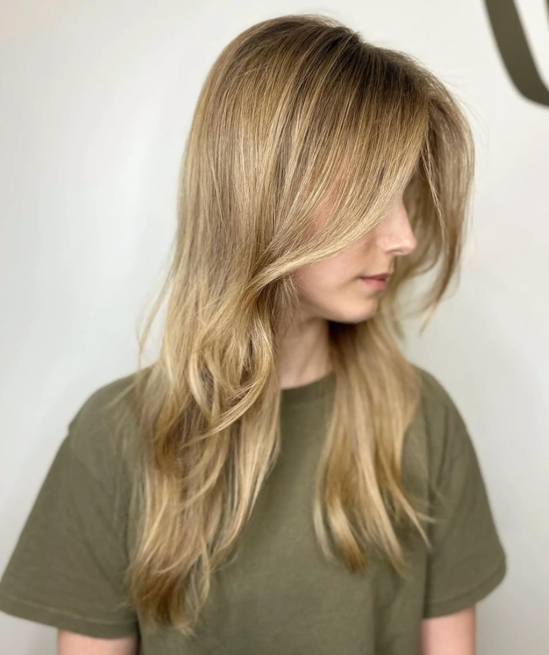 Long wavy blonde hair with side-swept bangs and face-framing layers, featuring a layered cut for added volume and texture.

Color by @simabeautynyc
 1
