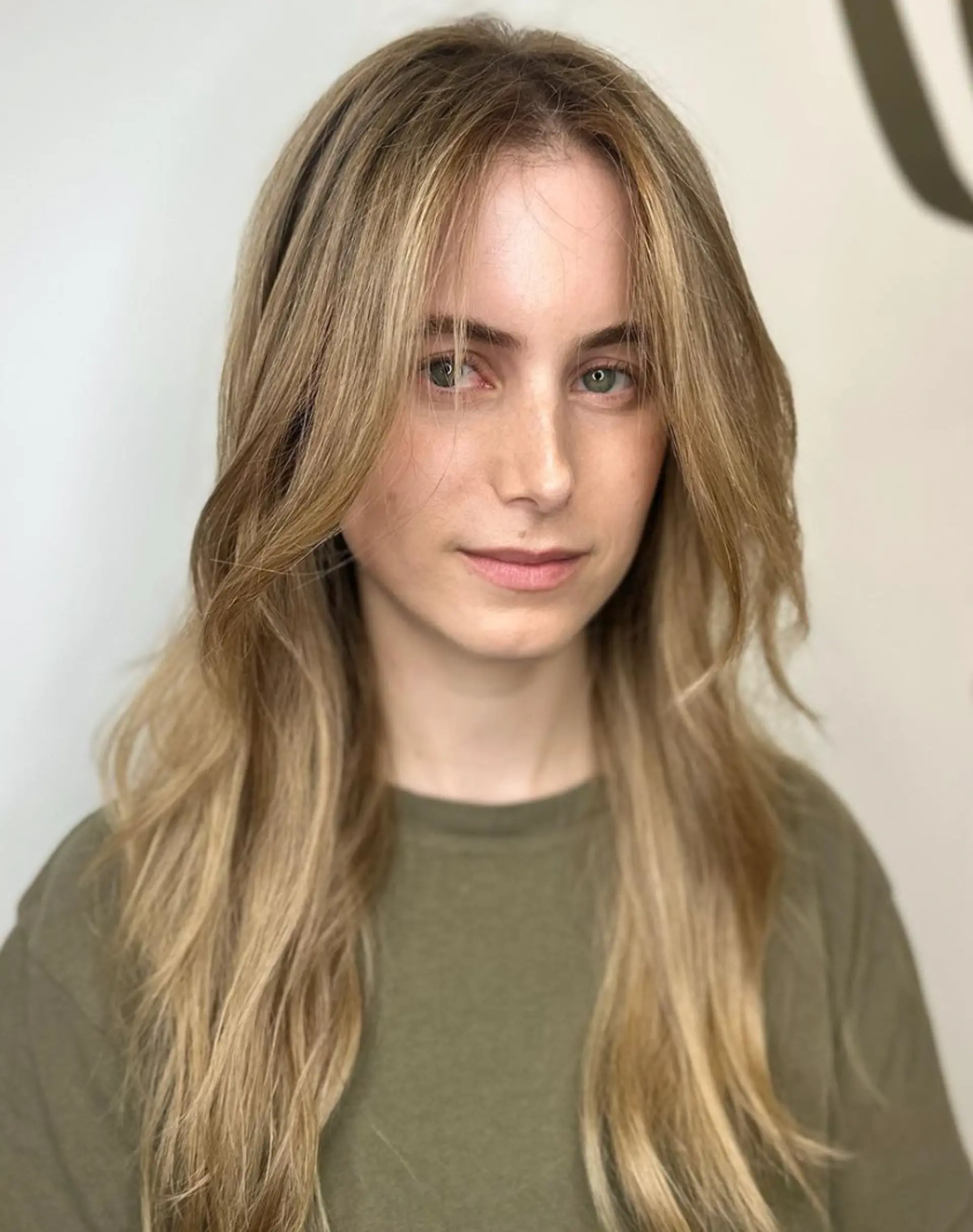Long wavy blonde hair with side-swept bangs and face-framing layers, featuring a layered cut for added volume and texture.

Color by @simabeautynyc
 2