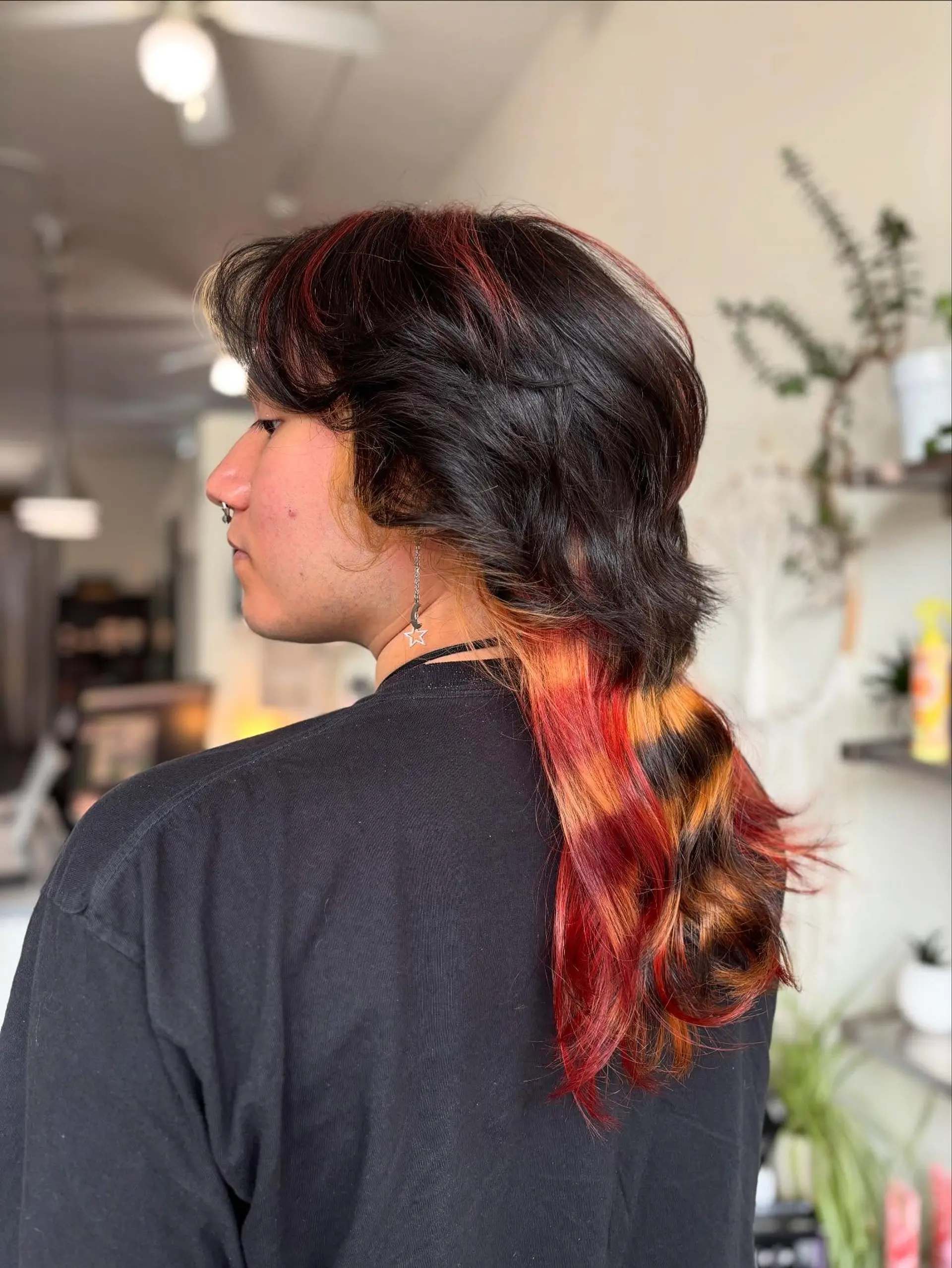 A layered alternative mullet featuring a dark wavy crown contrasted with vibrant calico raccoon-tail bands of red, copper, and black. 1