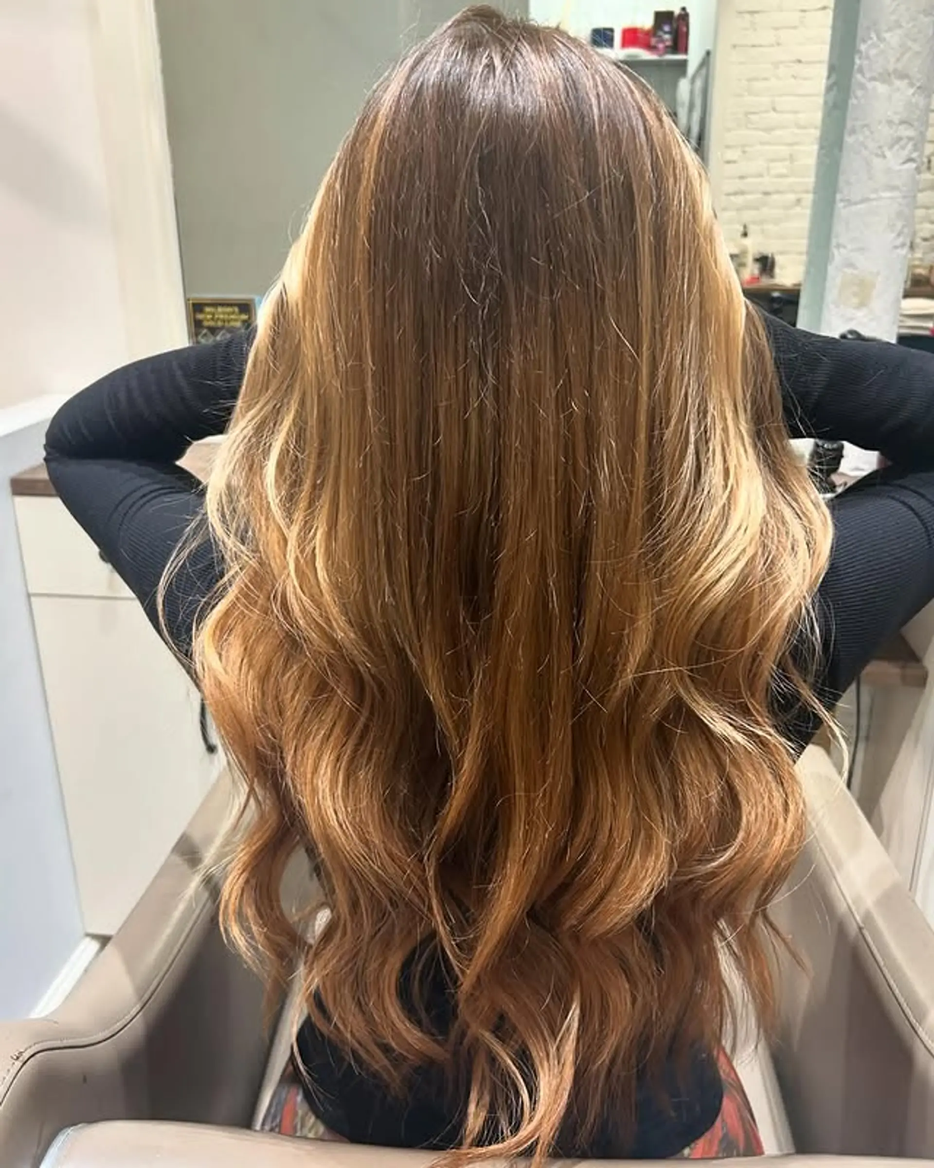 Long wavy hair with caramel swirl balayage, featuring layered ends. 1