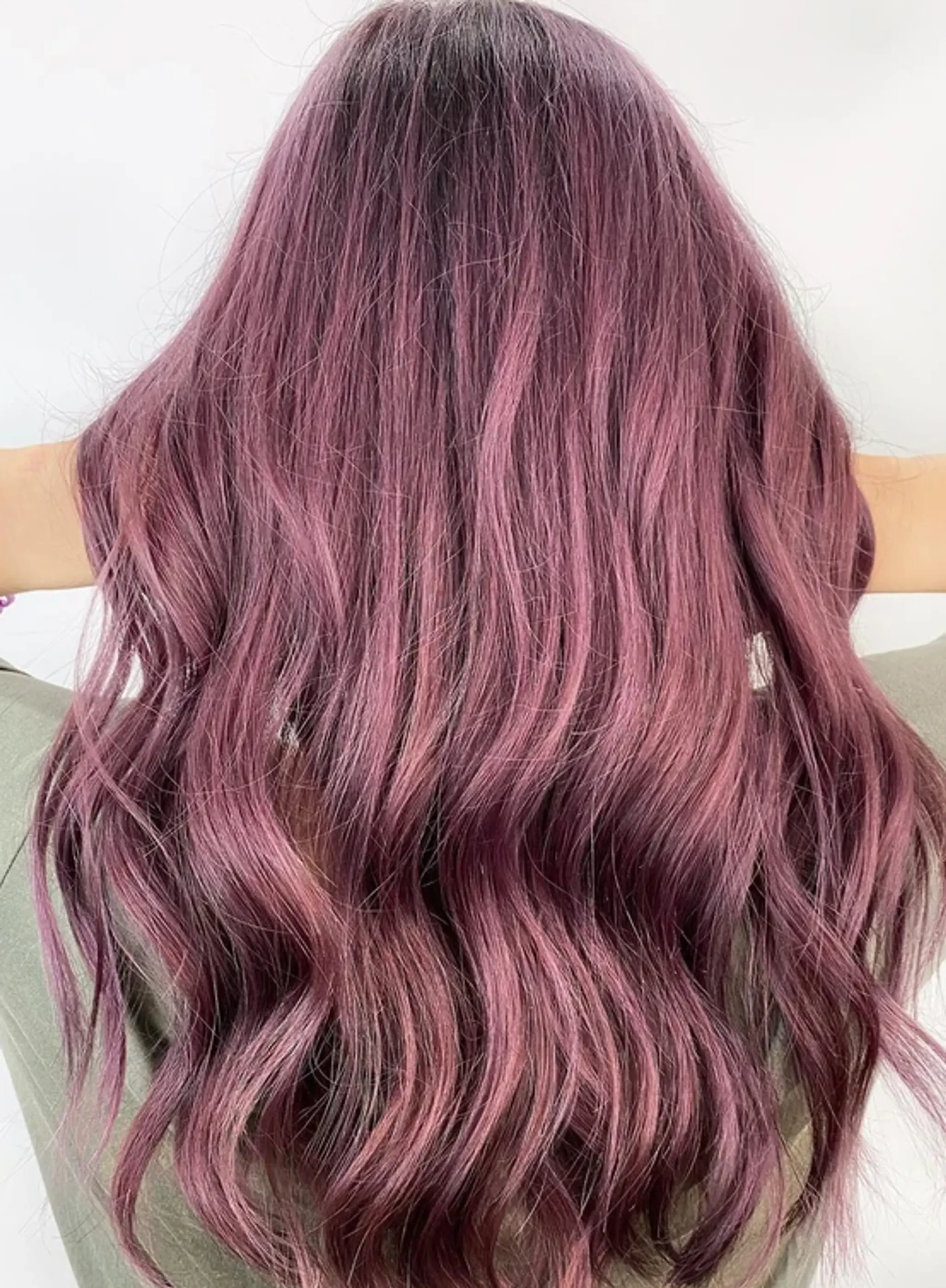 Long, wavy locks dyed in a striking shade of purple, with waves cascading down the back, highlighting the smooth texture and adding volume.
