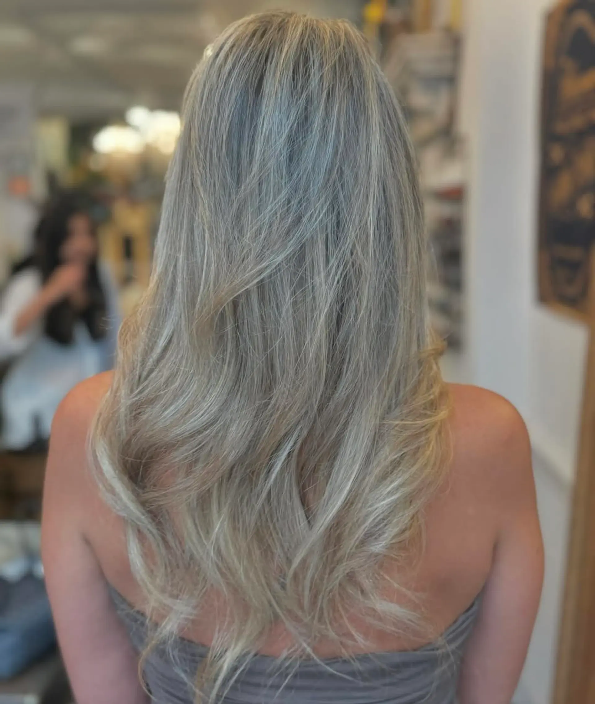 Long, wavy hair with a mix of silver and blonde tones, featuring layered waves and natural volume. 1