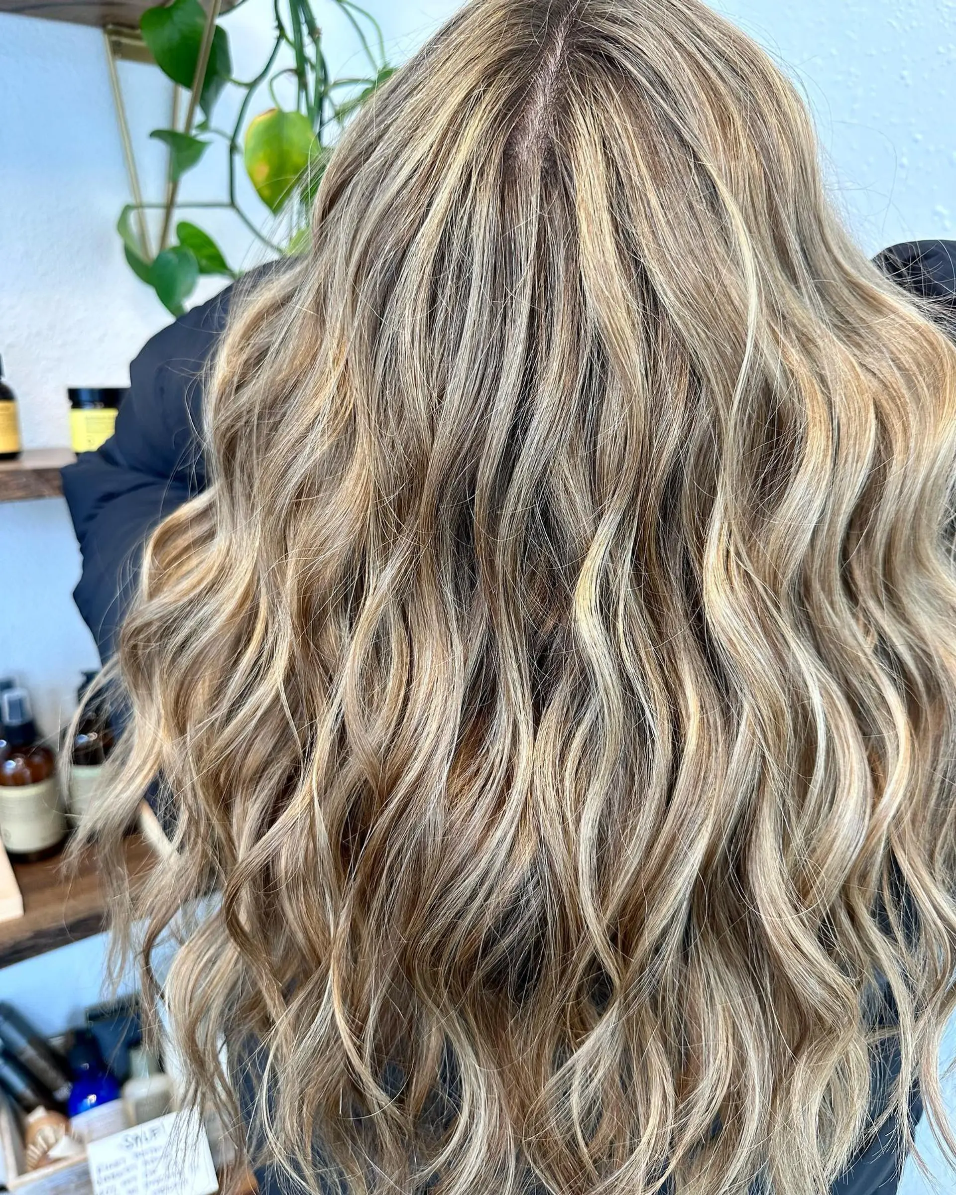 Long wavy hair enhanced with hand-painted blonde balayage for a seamless, sun-kissed dimension. 1