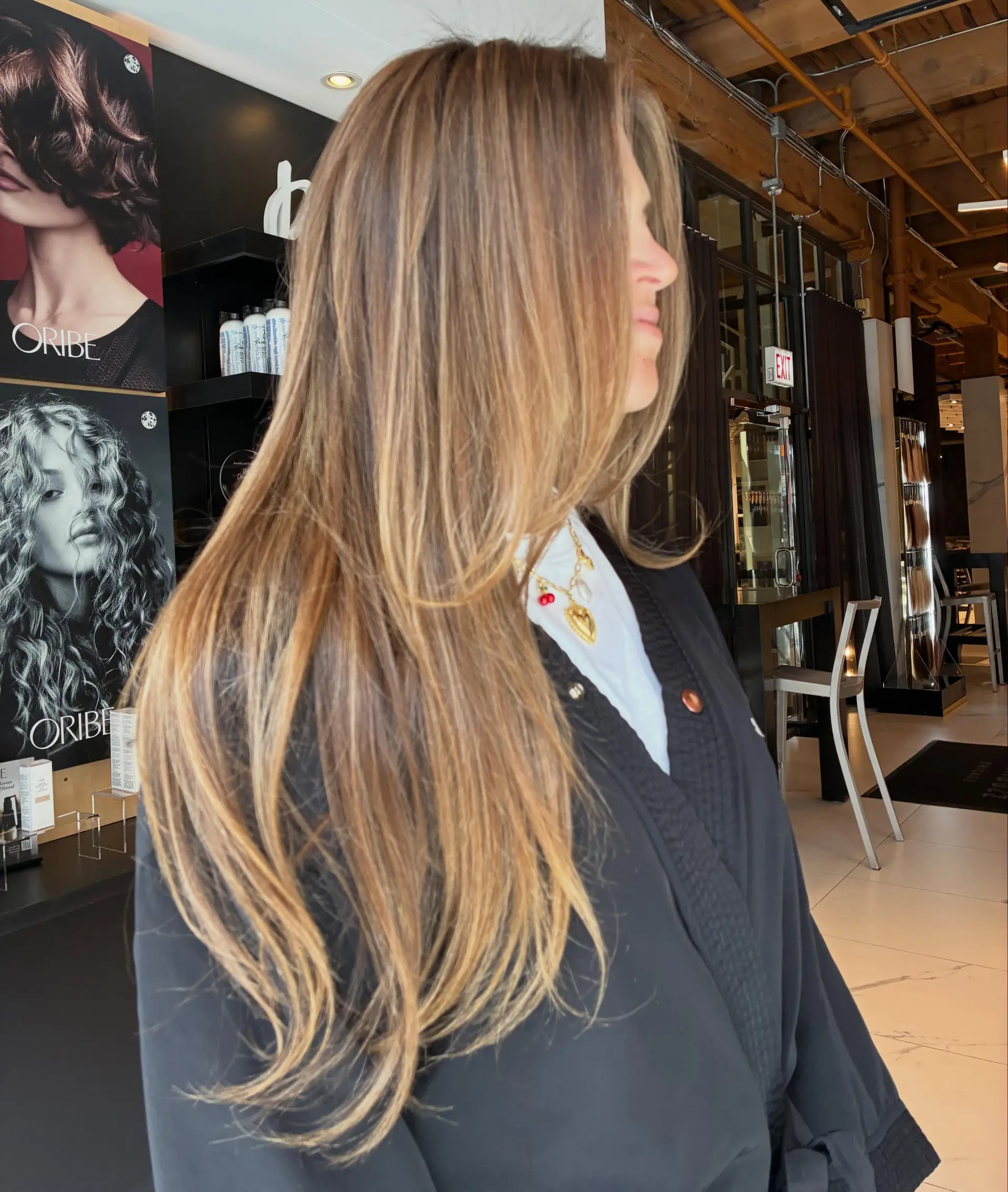 Long layered brunette hair with seamless warm honey and caramel balayage highlights. 1